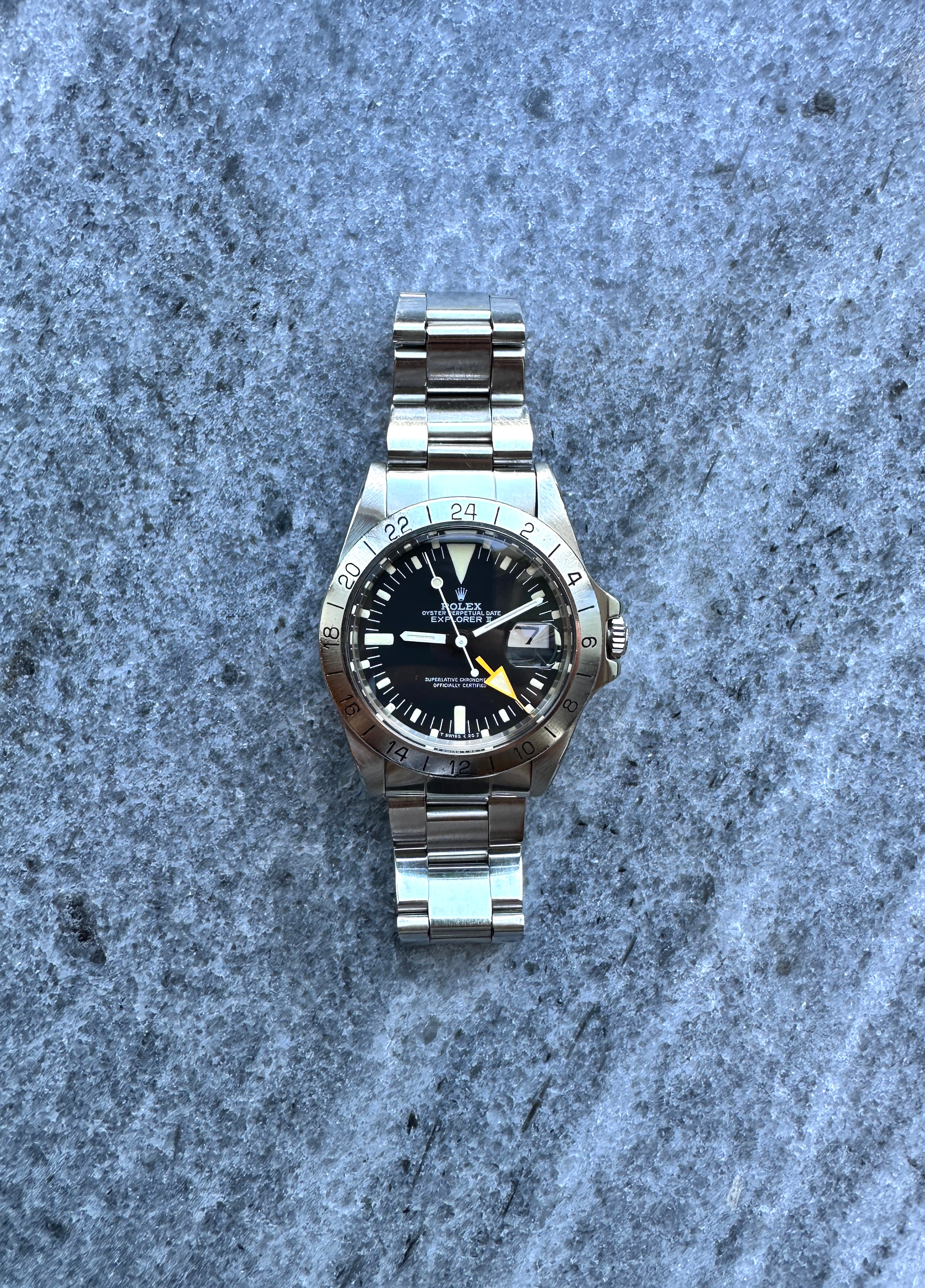 Rolex Explorer II "Freccione" MK 5 aus Stahl mit schwarzem Zifferblatt und 24-Stunden-Lünette auf grauem Hintergrund