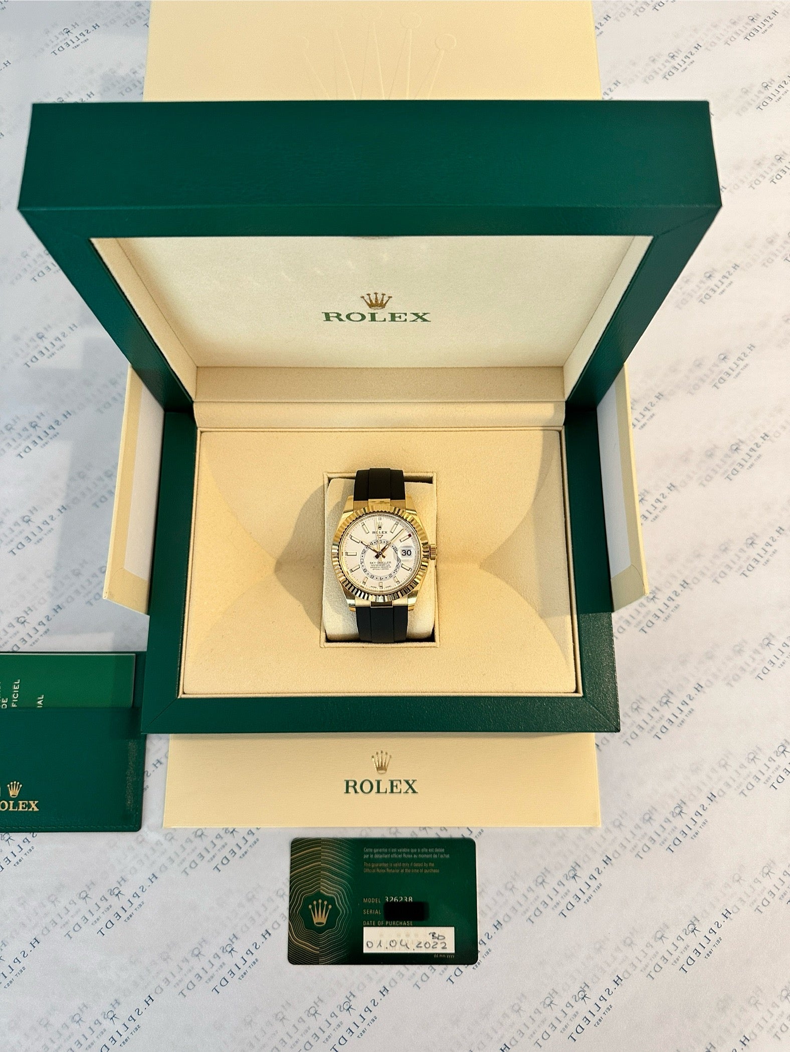 Rolex Sky-Dweller in Gelbgold mit Kautschukband, liegend in der grünen Box