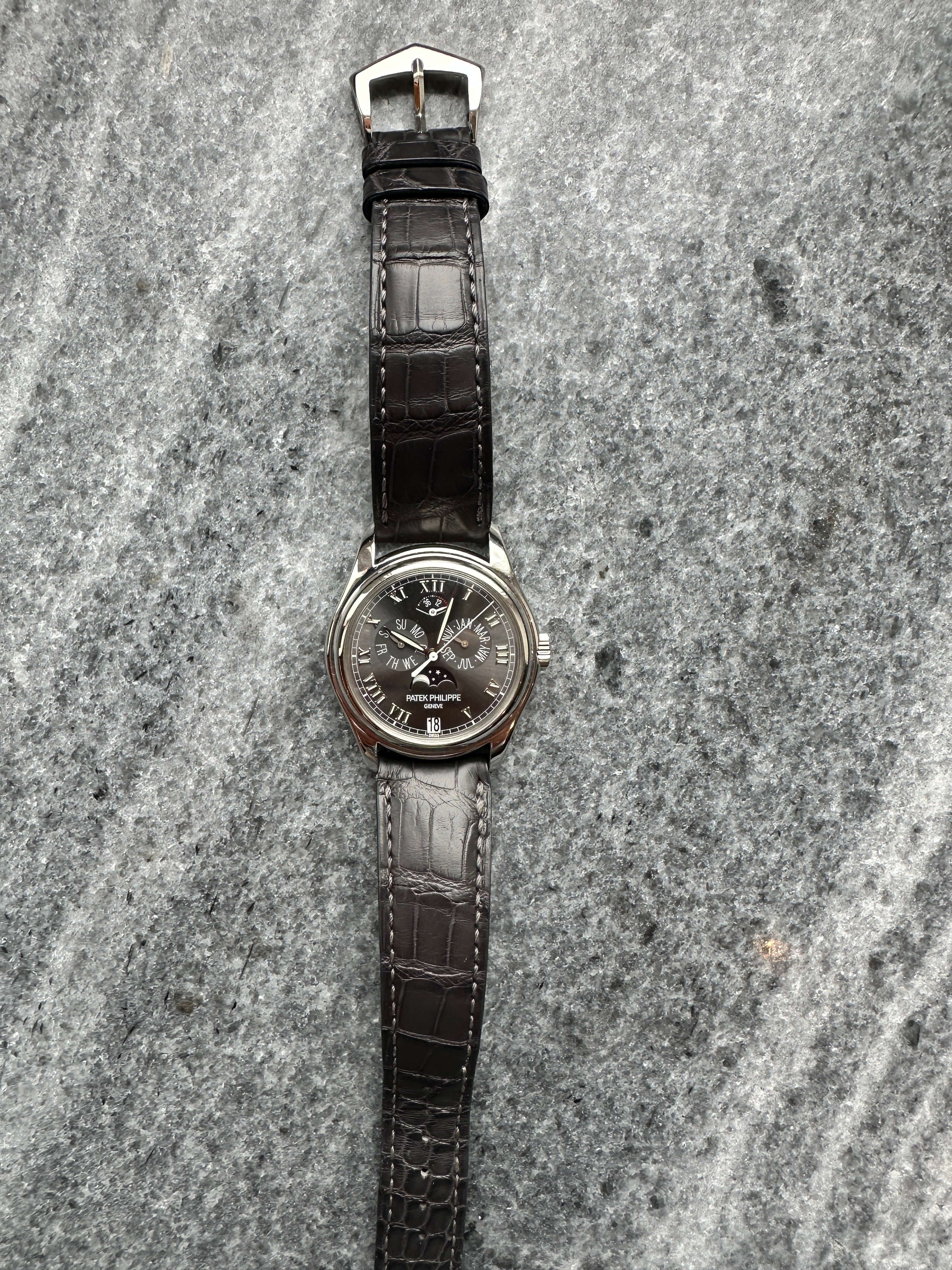 Patek Philippe Annual Calendar 5056P-001 in Platin mit schwarzem Lederarmband auf strukturiertem Untergrund
