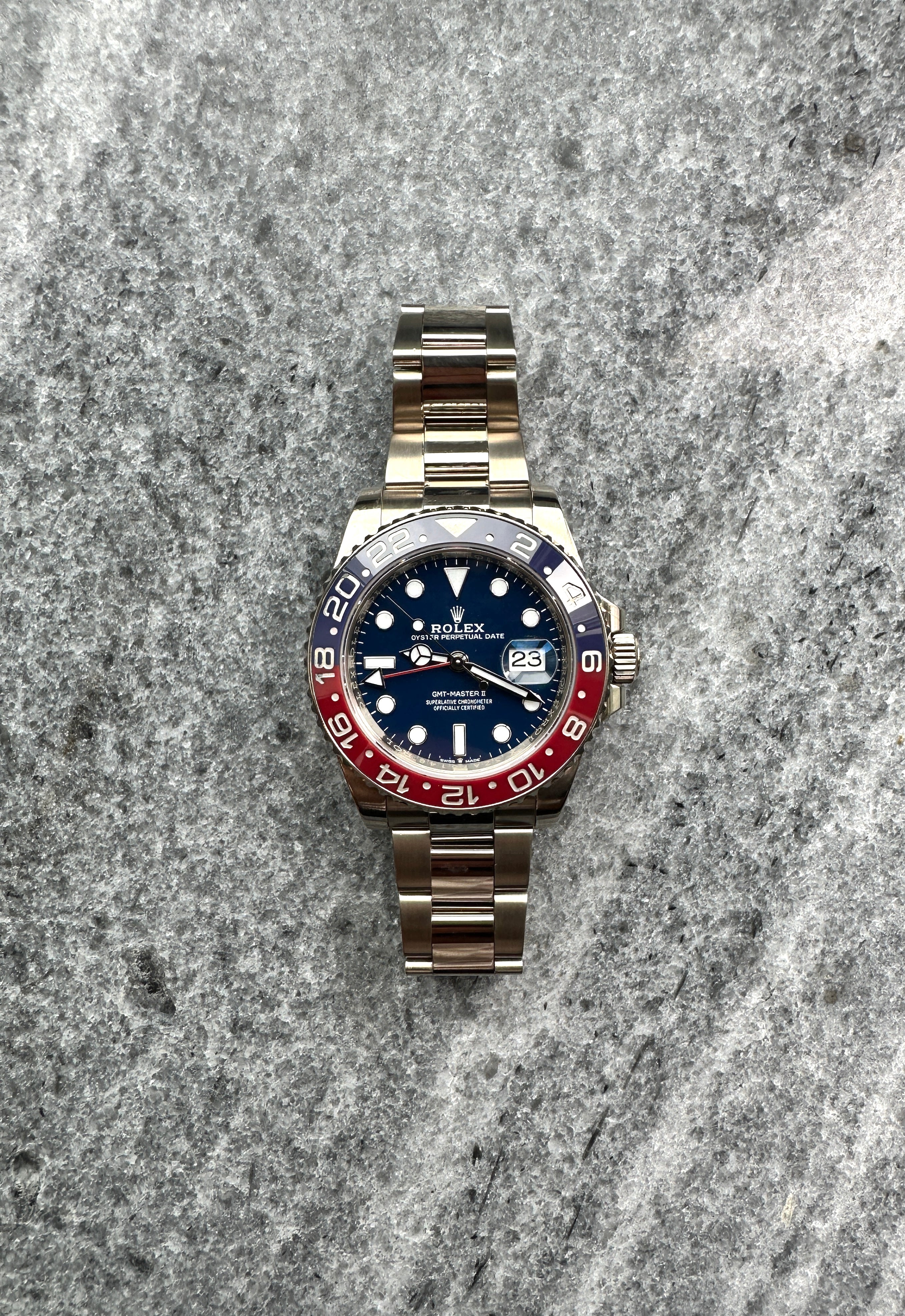 Rolex GMT-Master II aus Weißgold mit blauem Zifferblatt und zweifarbiger Lünette auf Steinuntergrund