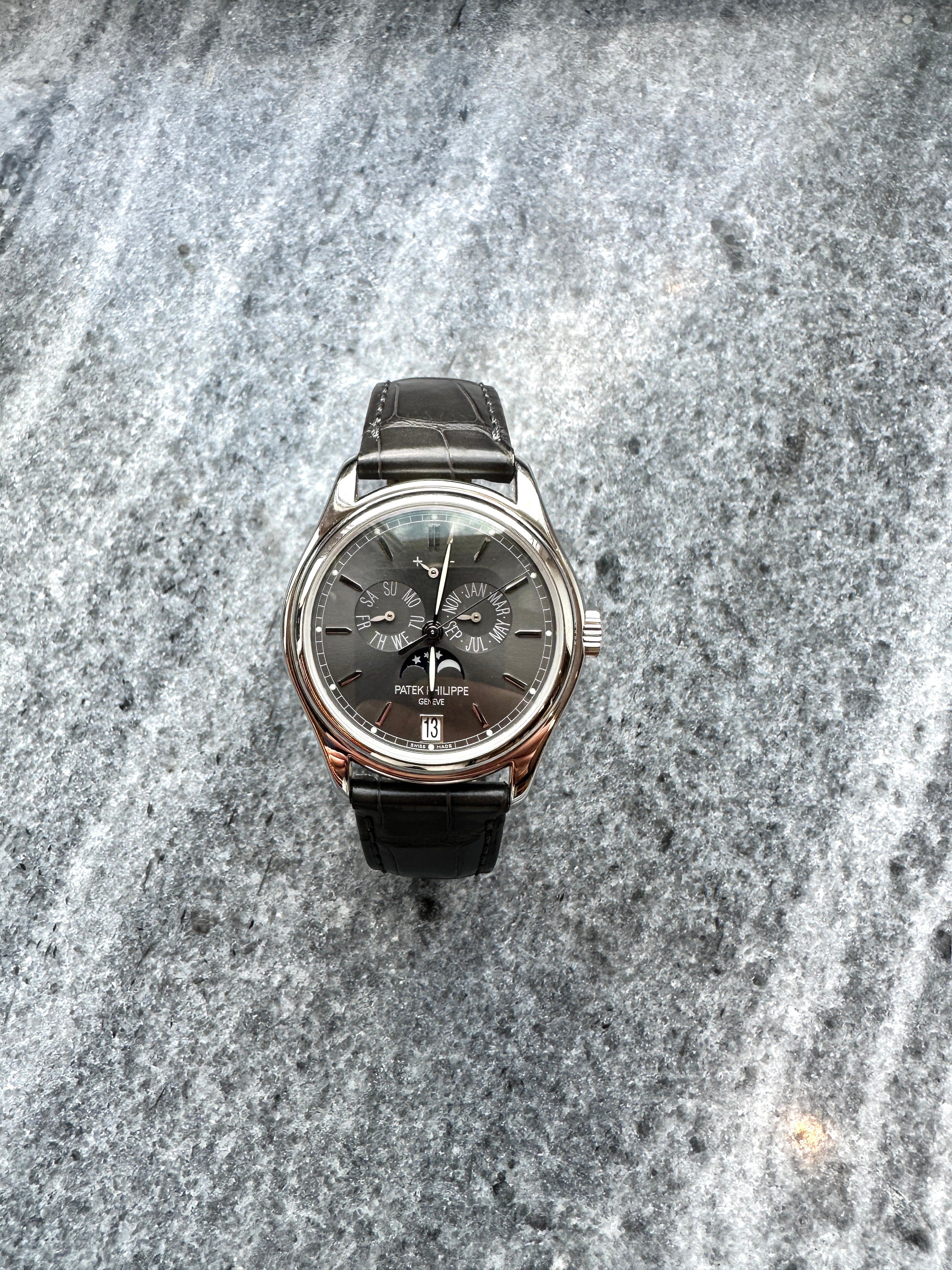 Patek Philippe 5146R-001 Platin Herrenuhr mit schwarzem Lederarmband im Vollbild auf grauem Steinuntergrund