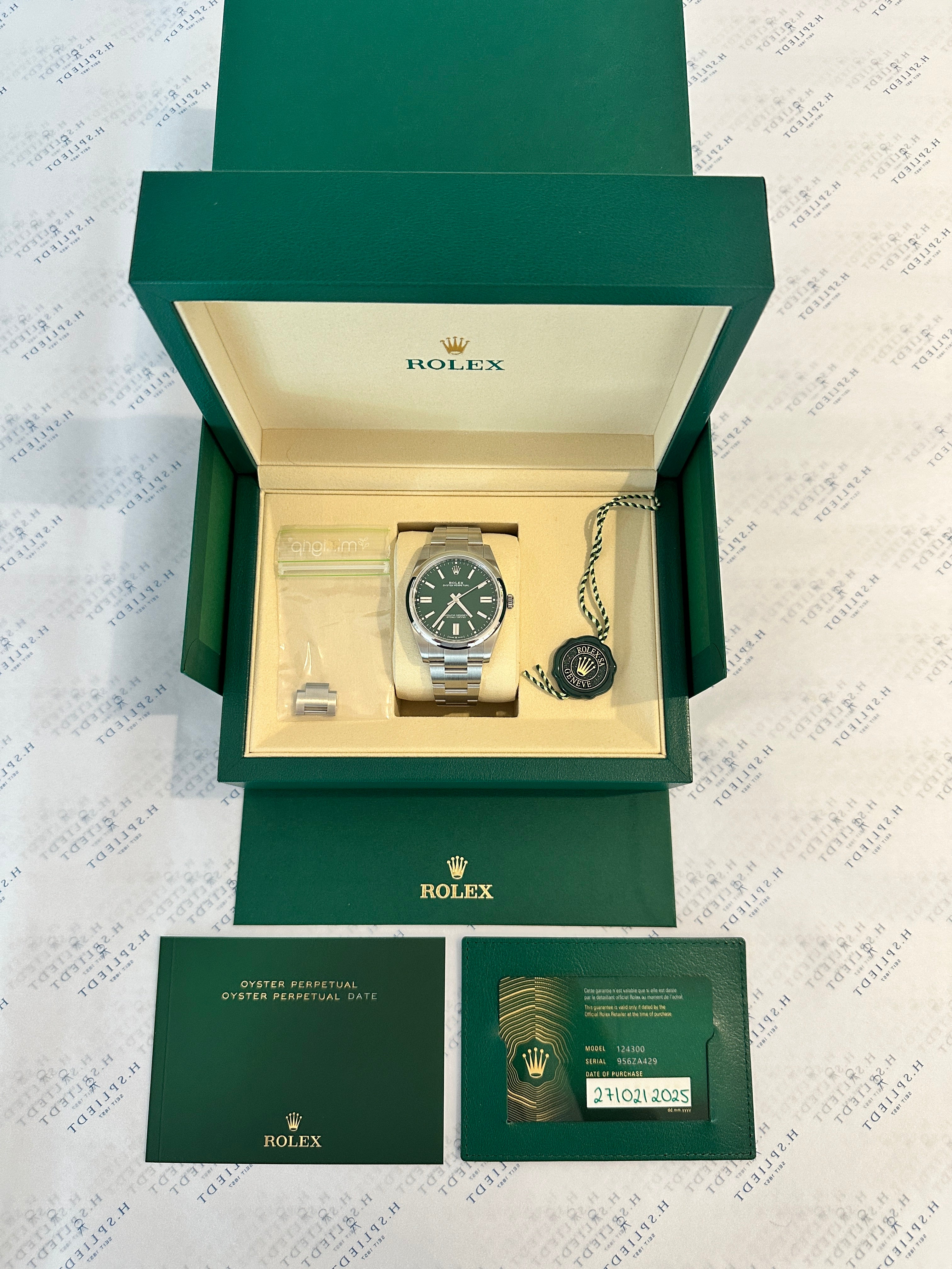 Rolex Oyster Perpetual 41mm in Stahl mit grünem Zifferblatt im geöffneten Karton mit Garantiekarte