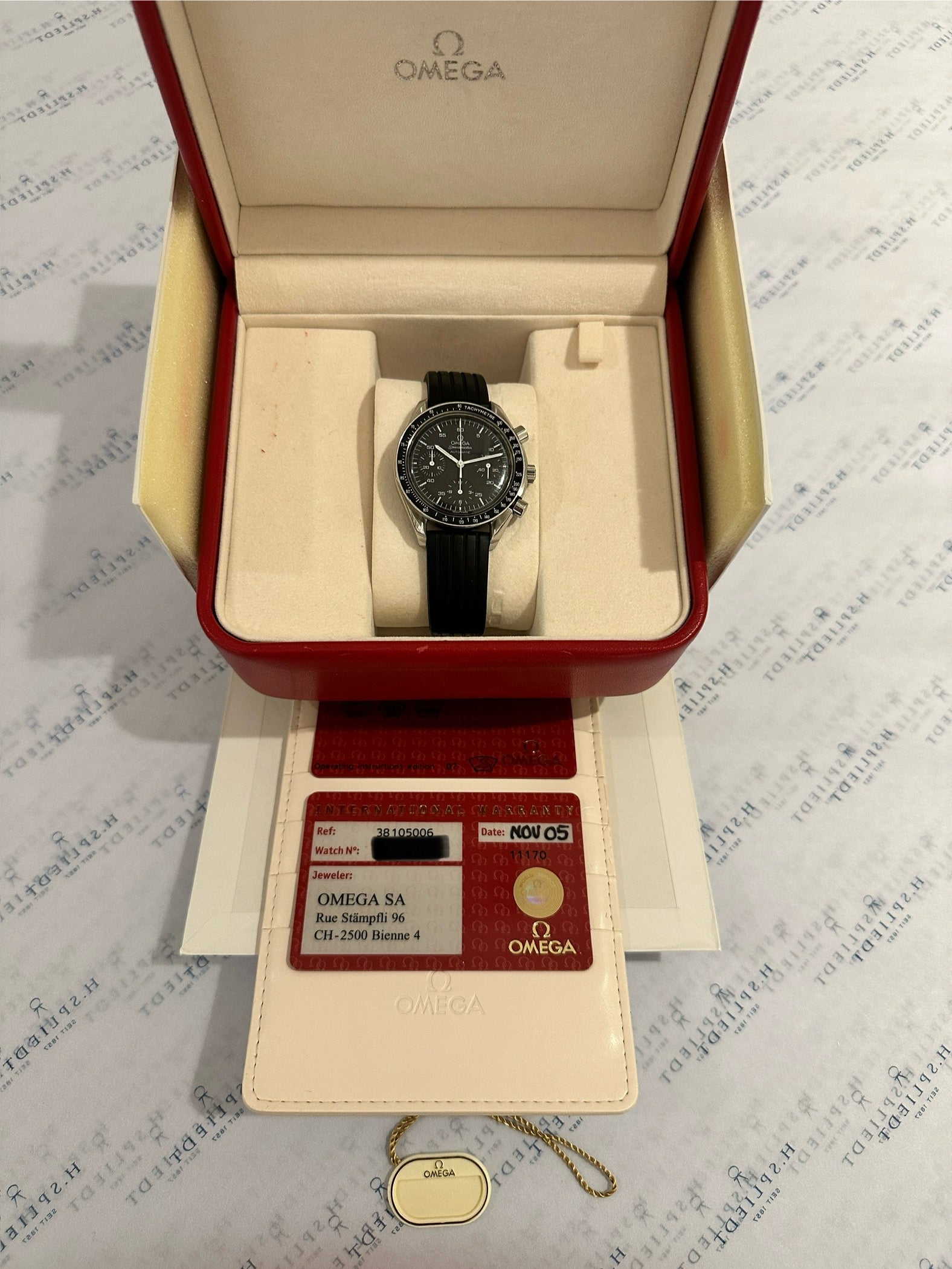 Omega Speedmaster Reduced Rubber in Stahl mit schwarzem Zifferblatt und schwarzem Band in der Verpackung