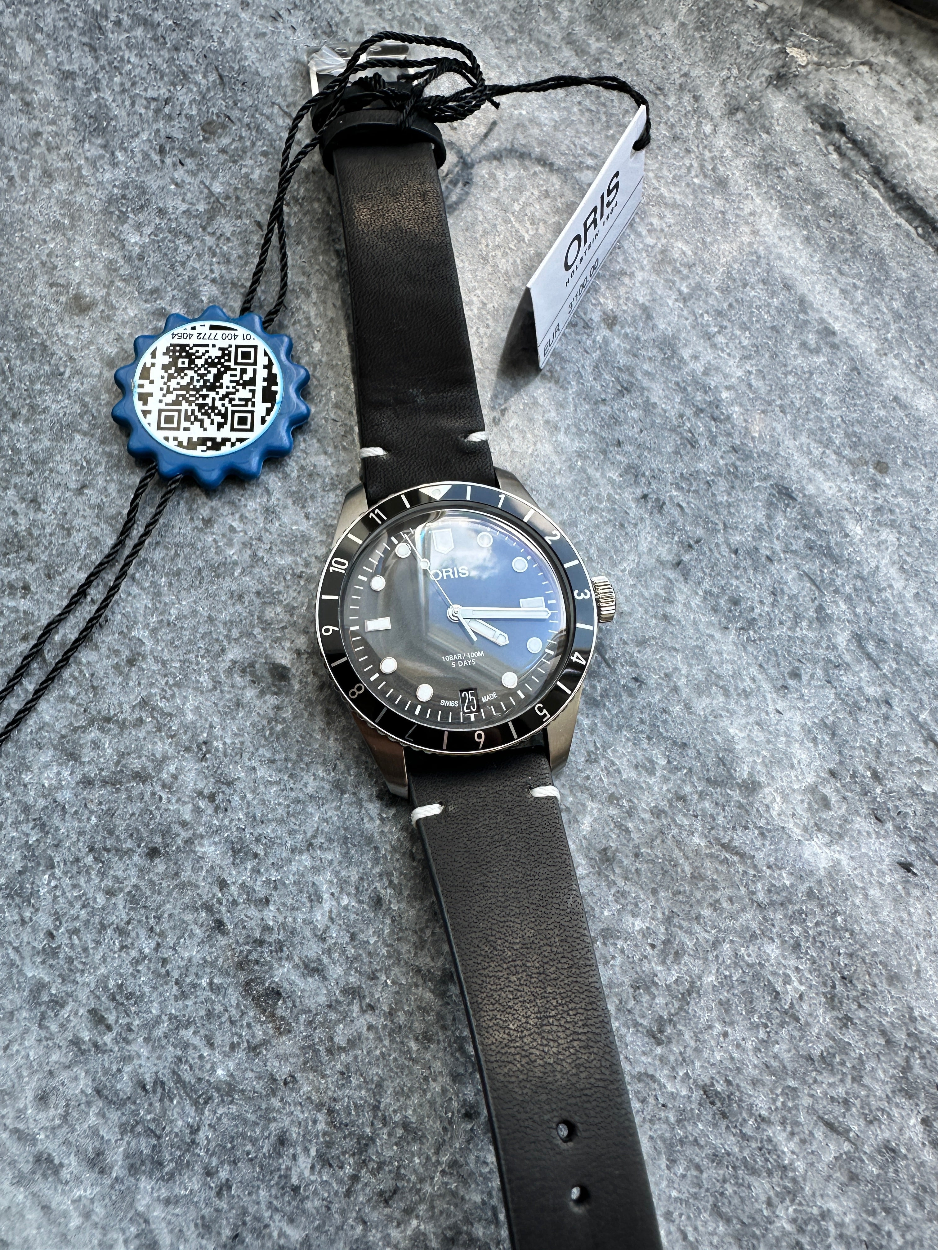 Oris Divers Sixty Five Automatik-Uhr mit schwarzem Lederarmband auf steinigem Untergrund