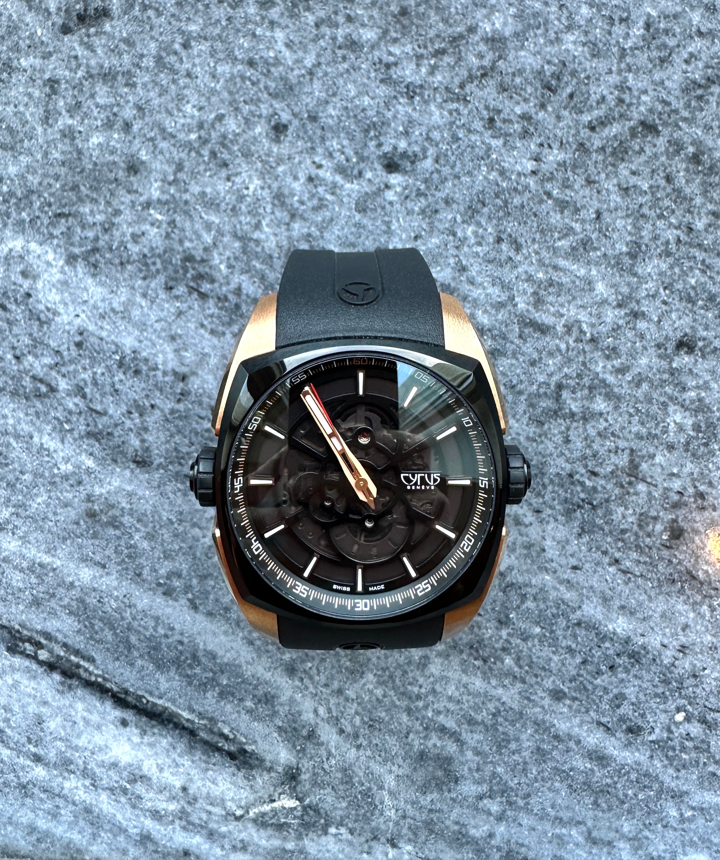 Cyrus Klepcys Solo Tempo aus Roségold und schwarzem Stahl mit skelettiertem Zifferblatt auf steinigem Untergrund