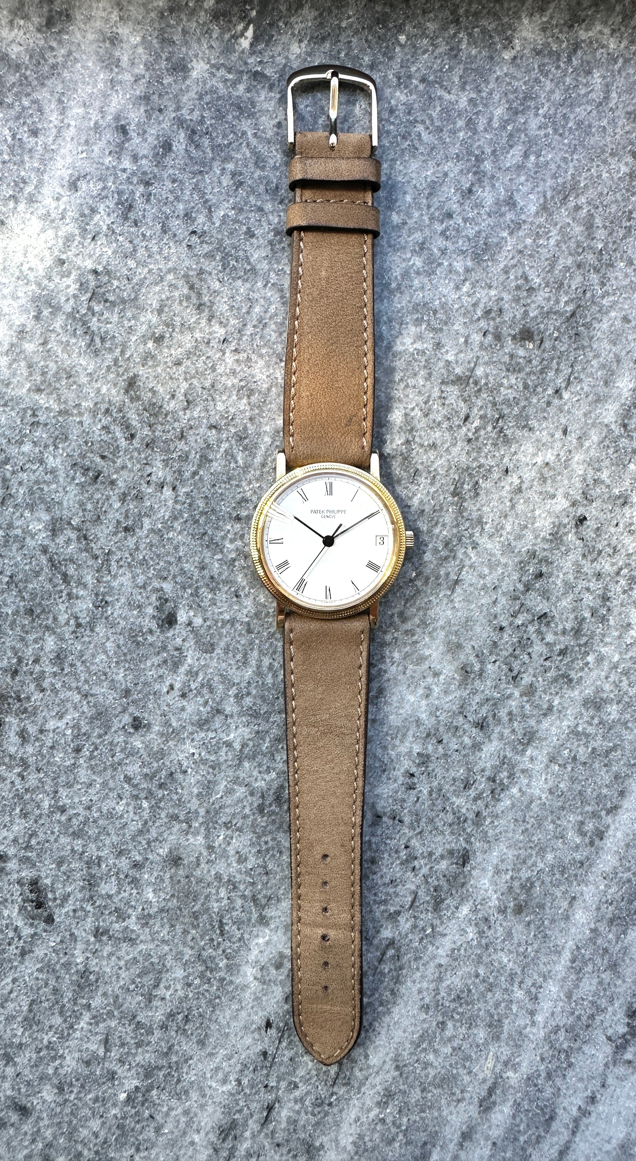 Patek Philippe Calatrava 3802 in Gelbgold mit braunem Lederarmband auf steinigem Untergrund