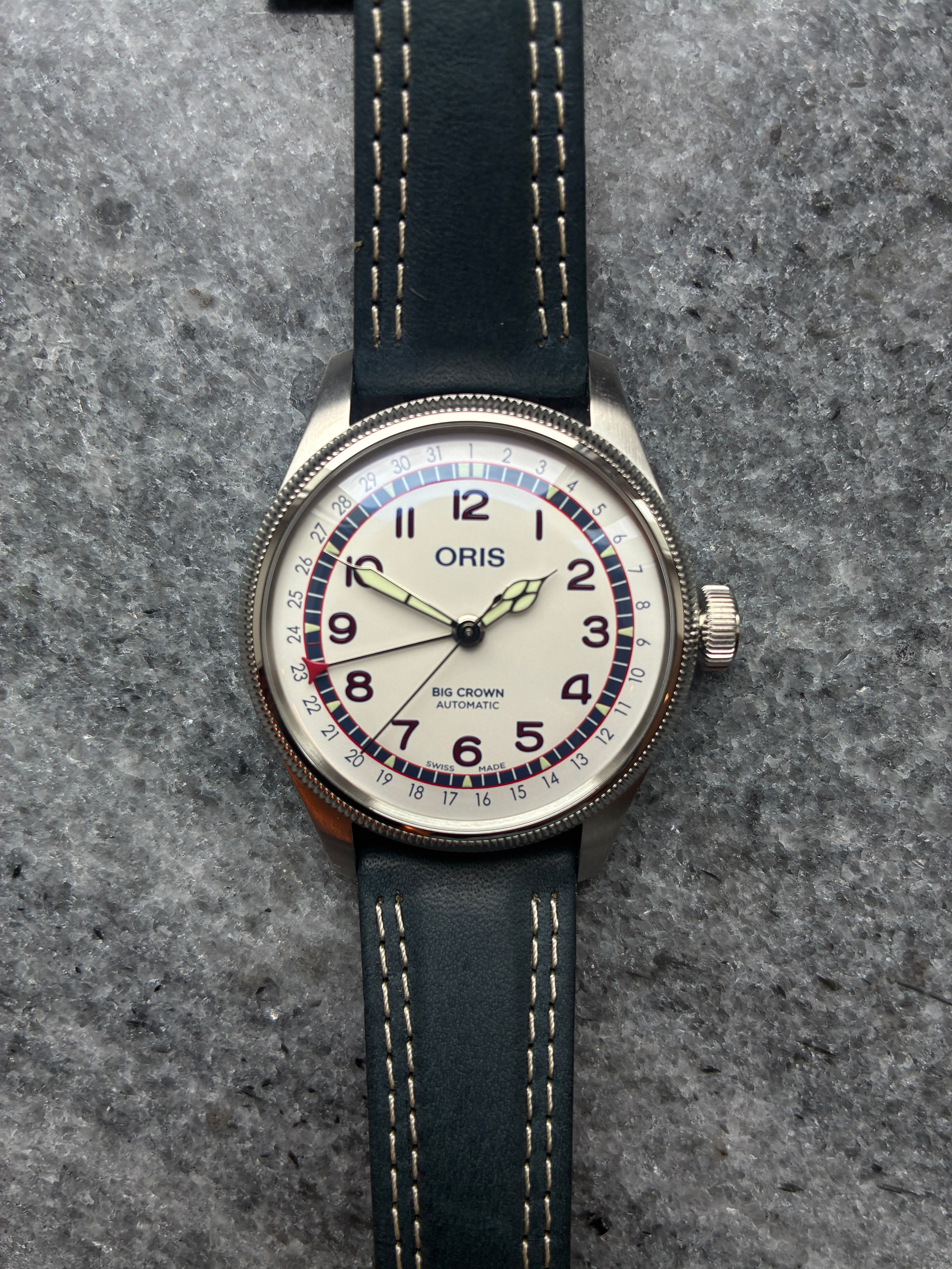 Oris Big Crown Automatic mit silbernem Zifferblatt und blauem Lederarmband auf Stein