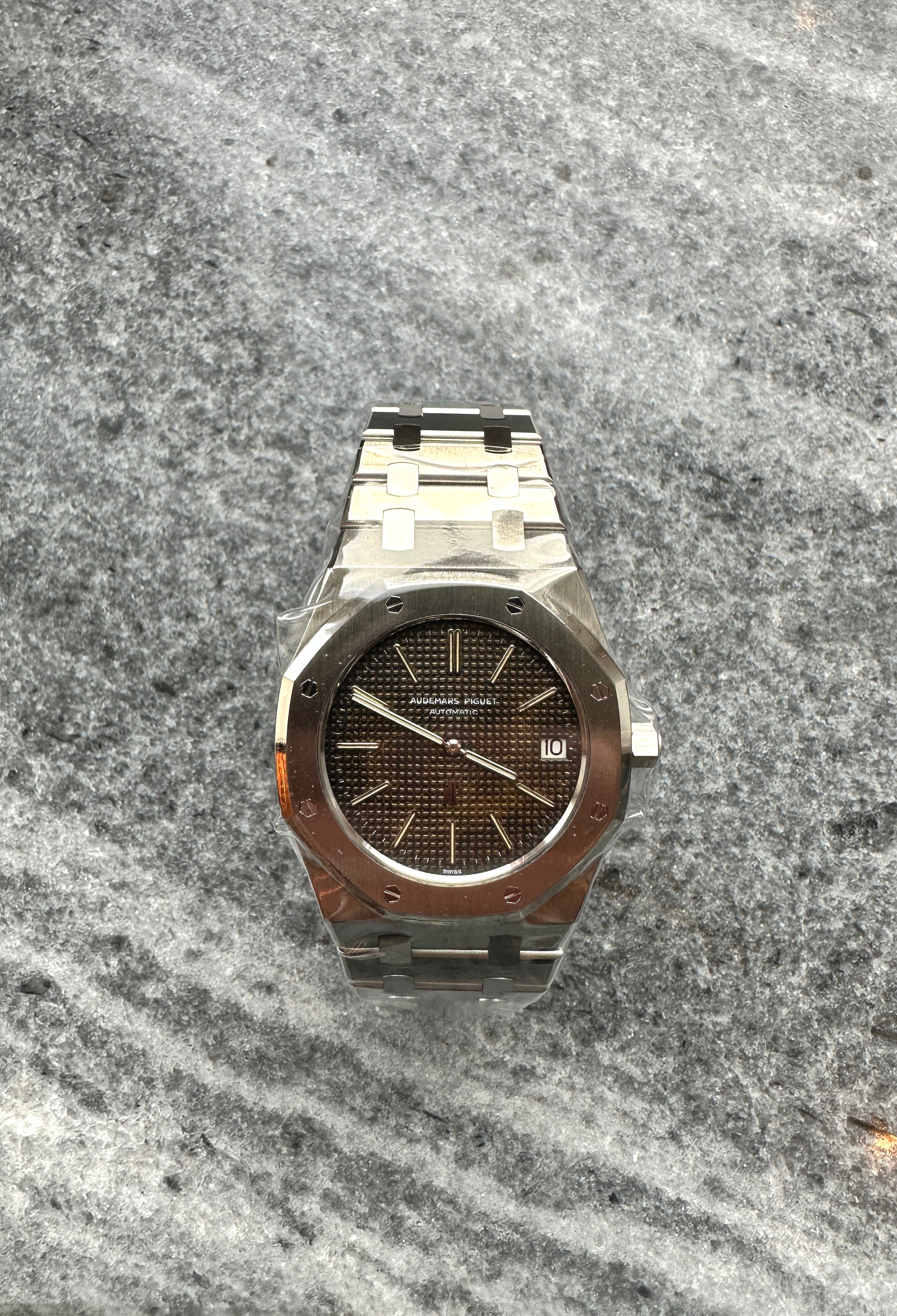 Audemars Piguet Royal Oak Jumbo 5402ST mit braunem Zifferblatt im Sichtfenster auf detailreichem Hintergrund