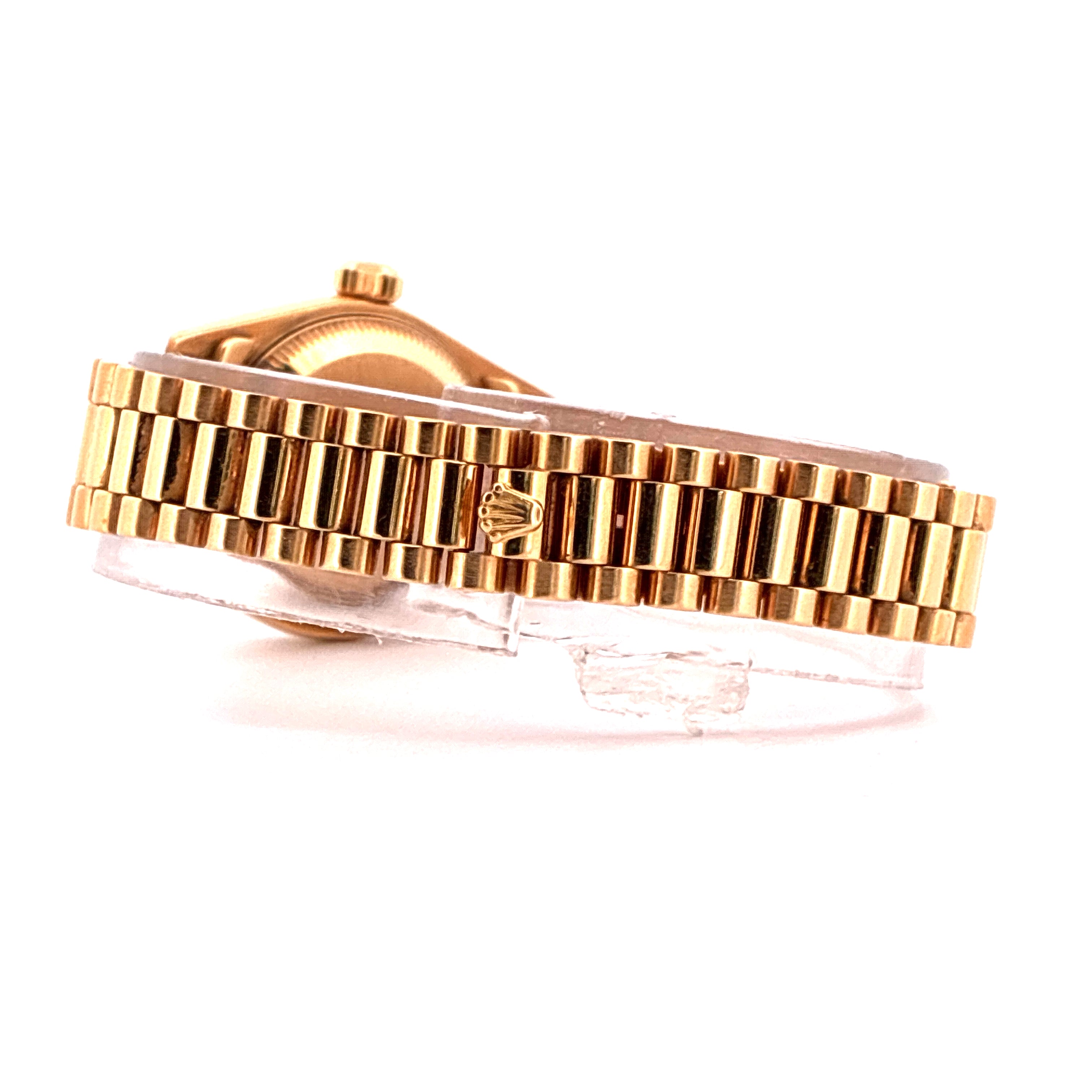 Seitenansicht einer goldenen Rolex Lady-Datejust mit geriffeltem Gehäuse und einem charakteristischen Kronenlogo auf dem Armband