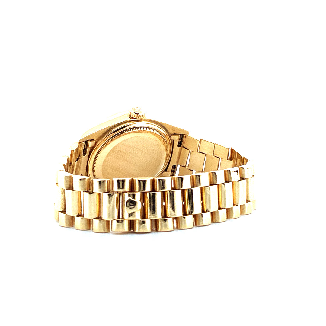 Seitenansicht einer Rolex Day-Date 36mm Gelbgold Uhr mit glänzendem Präsidentenarmband vor neutralem Hintergrund