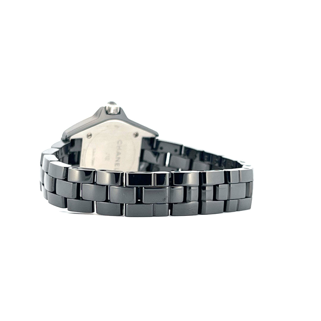 Seitenansicht einer Chanel J12 Keramikuhr mit schwarzem Gliederarmband auf weißem Hintergrund