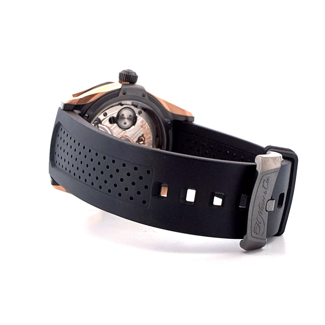 Moser Pioneer Tourbillon mit schwarzem Kautschukarmband und Dornschließe auf weißem Hintergrund
