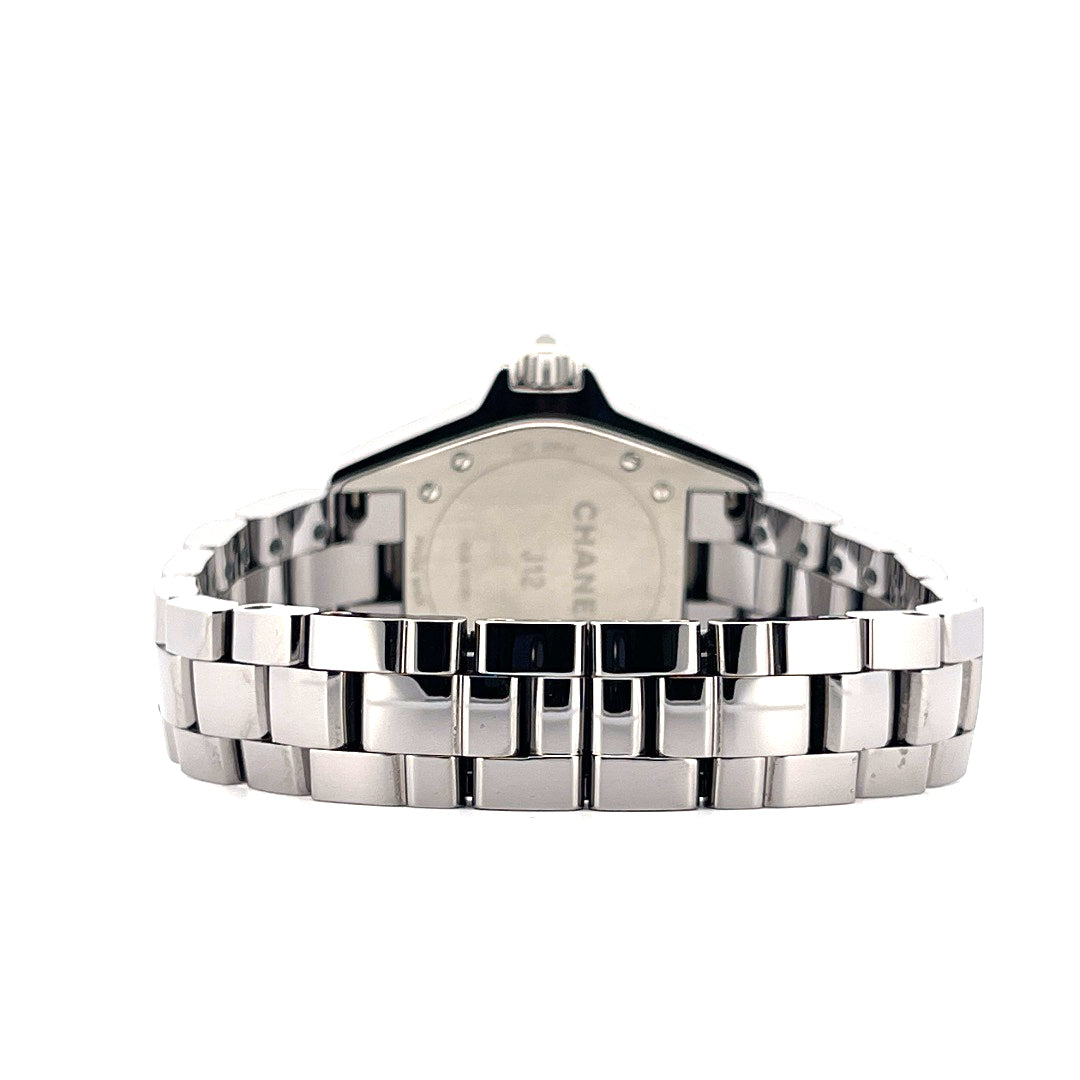 Rückseite einer ungetragenen Chanel J12 33mm Keramikuhr mit Metallarmband und der Aufschrift "Chanel J12" auf weißem Hinte…