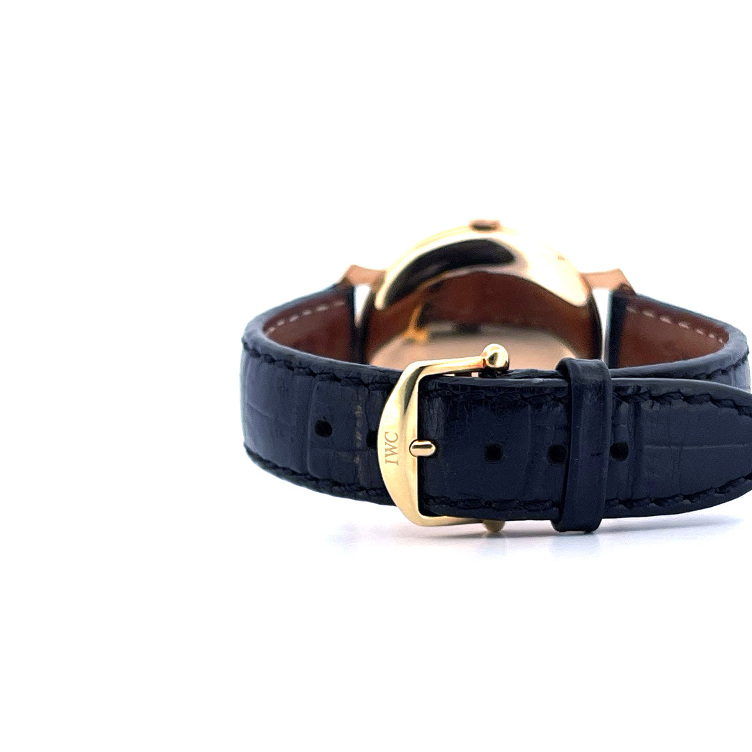 Detailaufnahme einer IWC Uhr mit schwarzem Krokolederarmband und goldener Dornschliesse
