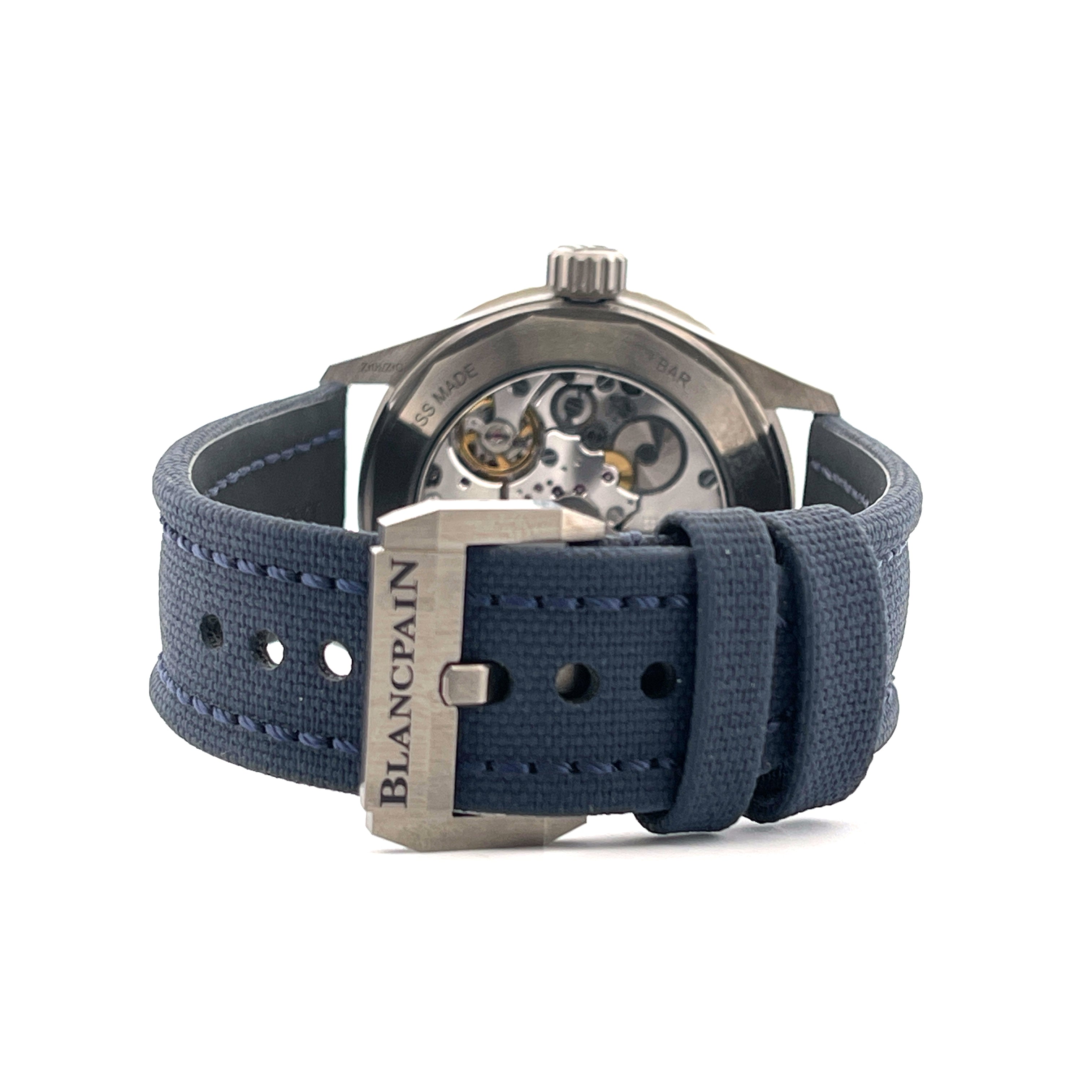 Blancpain Fifty Fathoms mit blauem Textilarmband und Sichtboden auf weißem Hintergrund