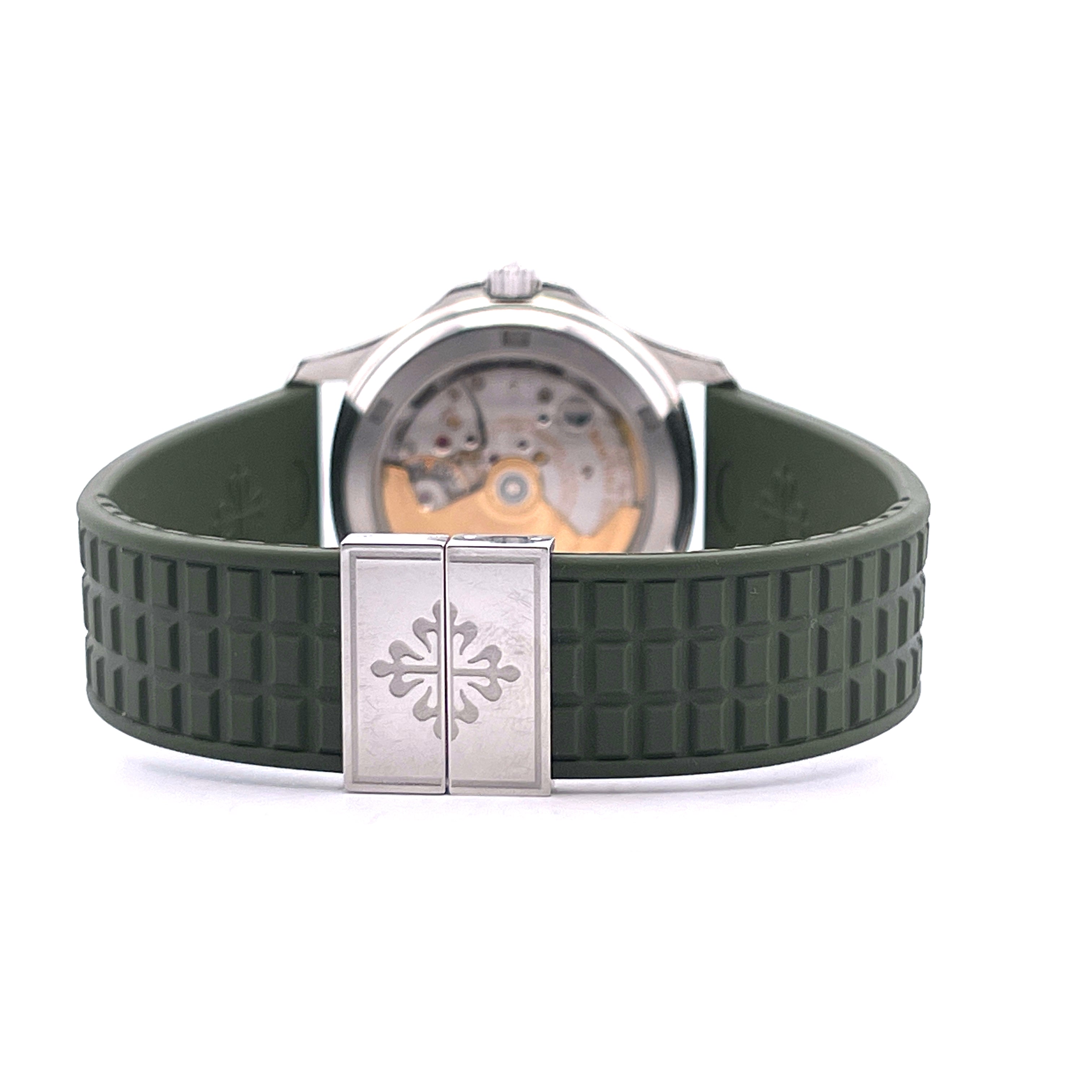 Patek Philippe Aquanaut 38mm im Detail Ansicht des Automatikwerks und des silbernen Verschlusses mit Logo auf dunkelgrünem Armband