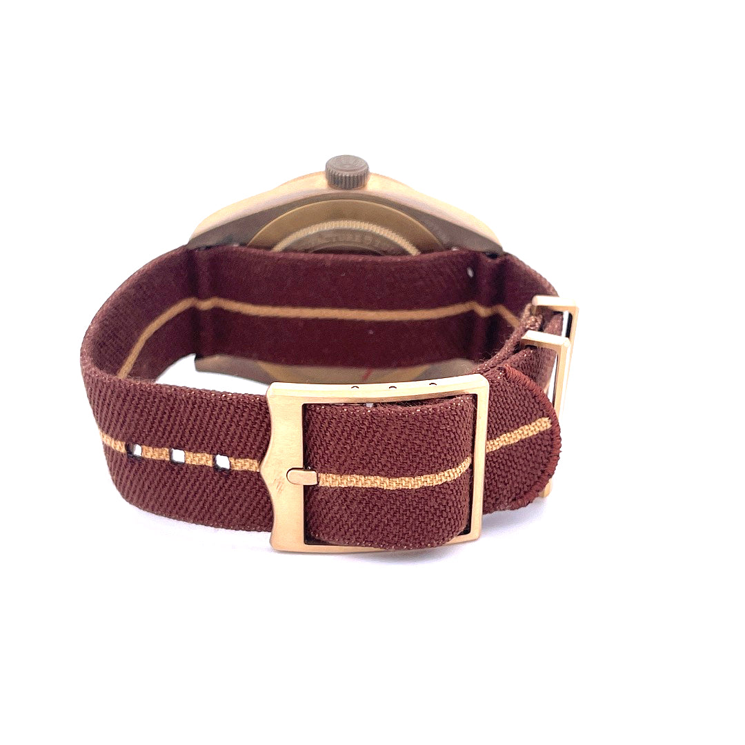 Seitenansicht einer Tudor Black Bay Fifty-eight Boutique Edition mit bronzefarbener Schließe und bordeauxfarbenem Stoffband