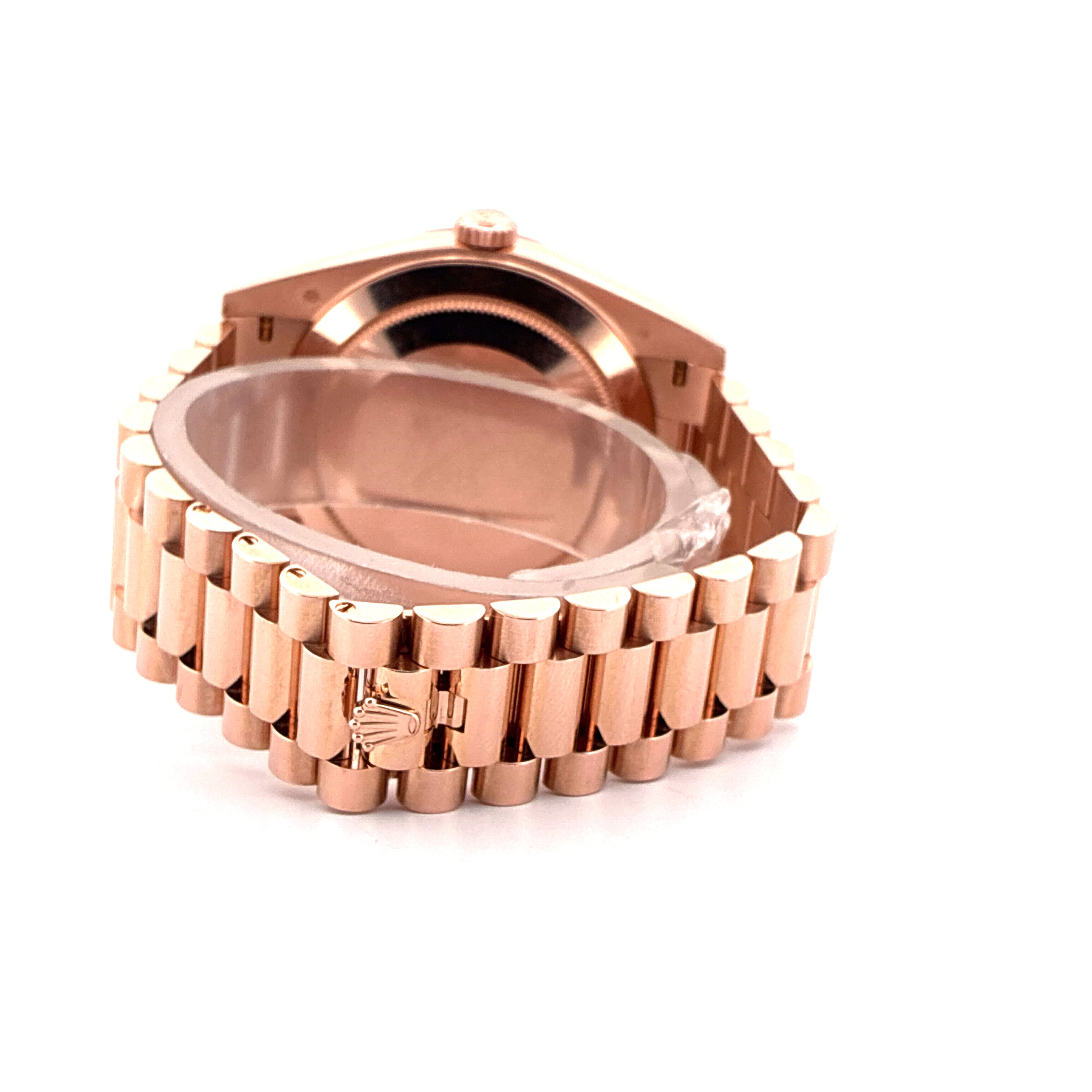 Rolex Day-Date 40 Roségold im Detail mit Faltschließe und teilweisem Armband auf weißem Hintergrund