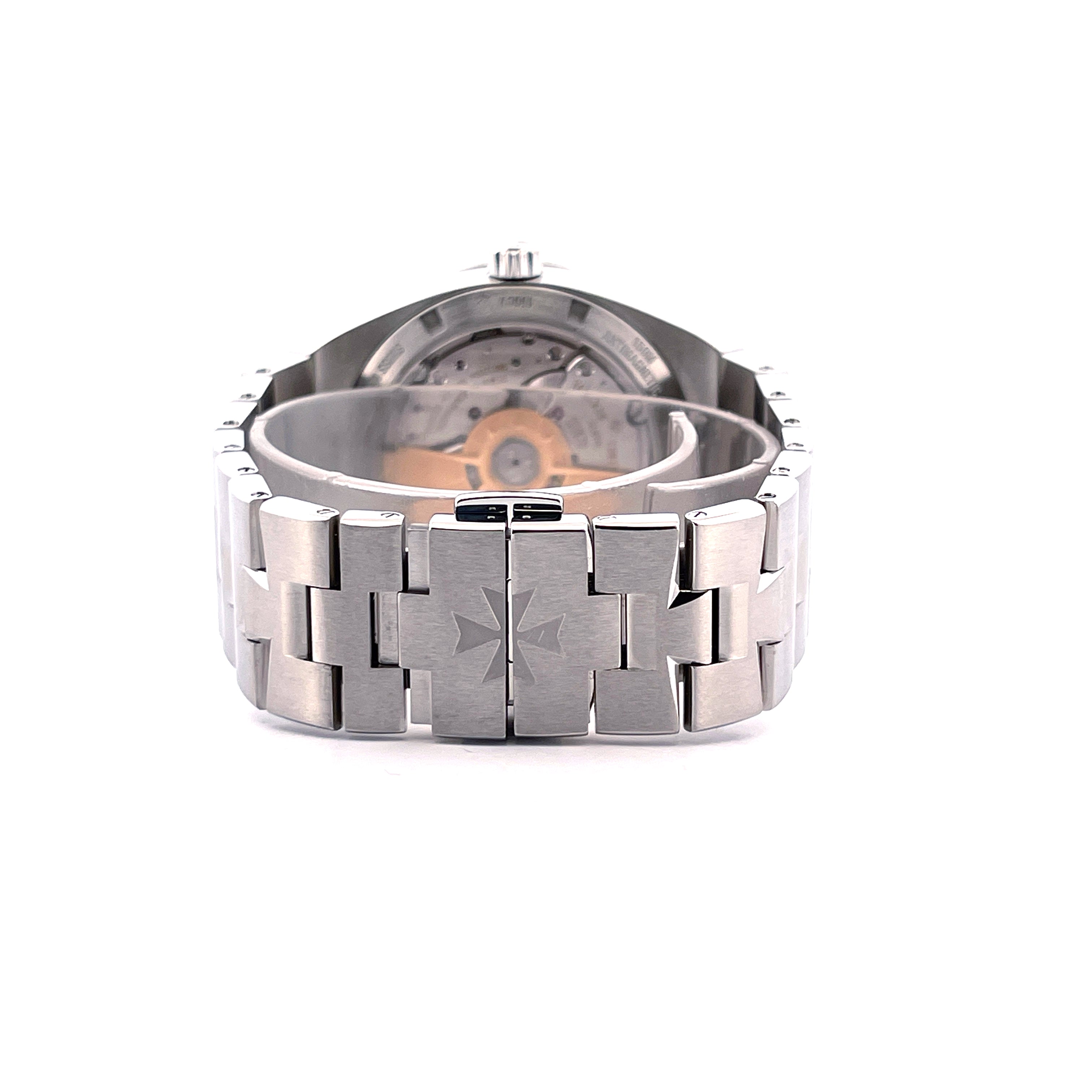 Vacheron Constantin Overseas Edelstahl Automatik, Ansicht des Armbands mit Malteserkreuz-Symbol und dem detaillierten Gehäusedeckel im Hintergrund