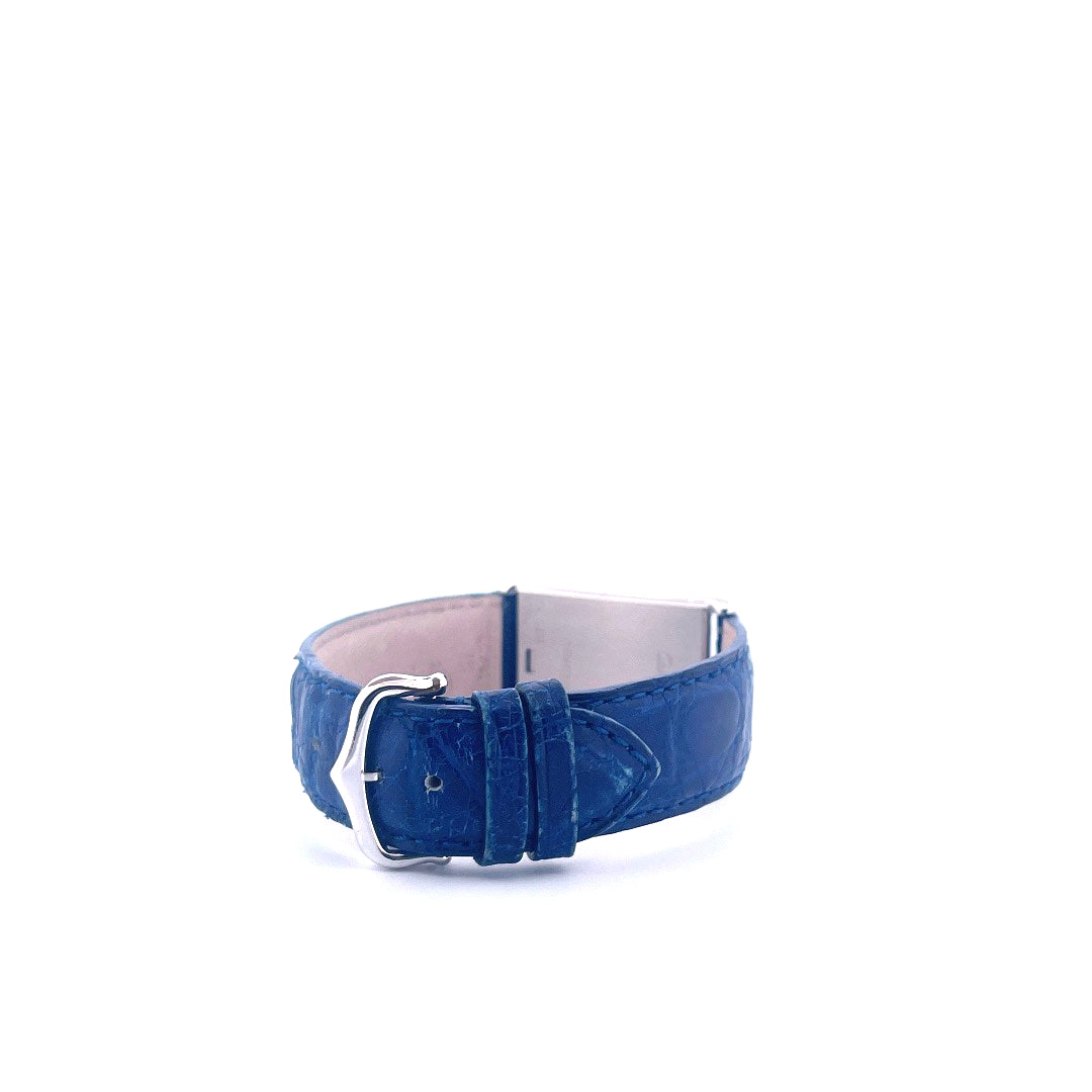 Nahaufnahme eines blauen Cartier Tank Basculante Lederarmbands mit Silberschließe vor weißem Hintergrund
