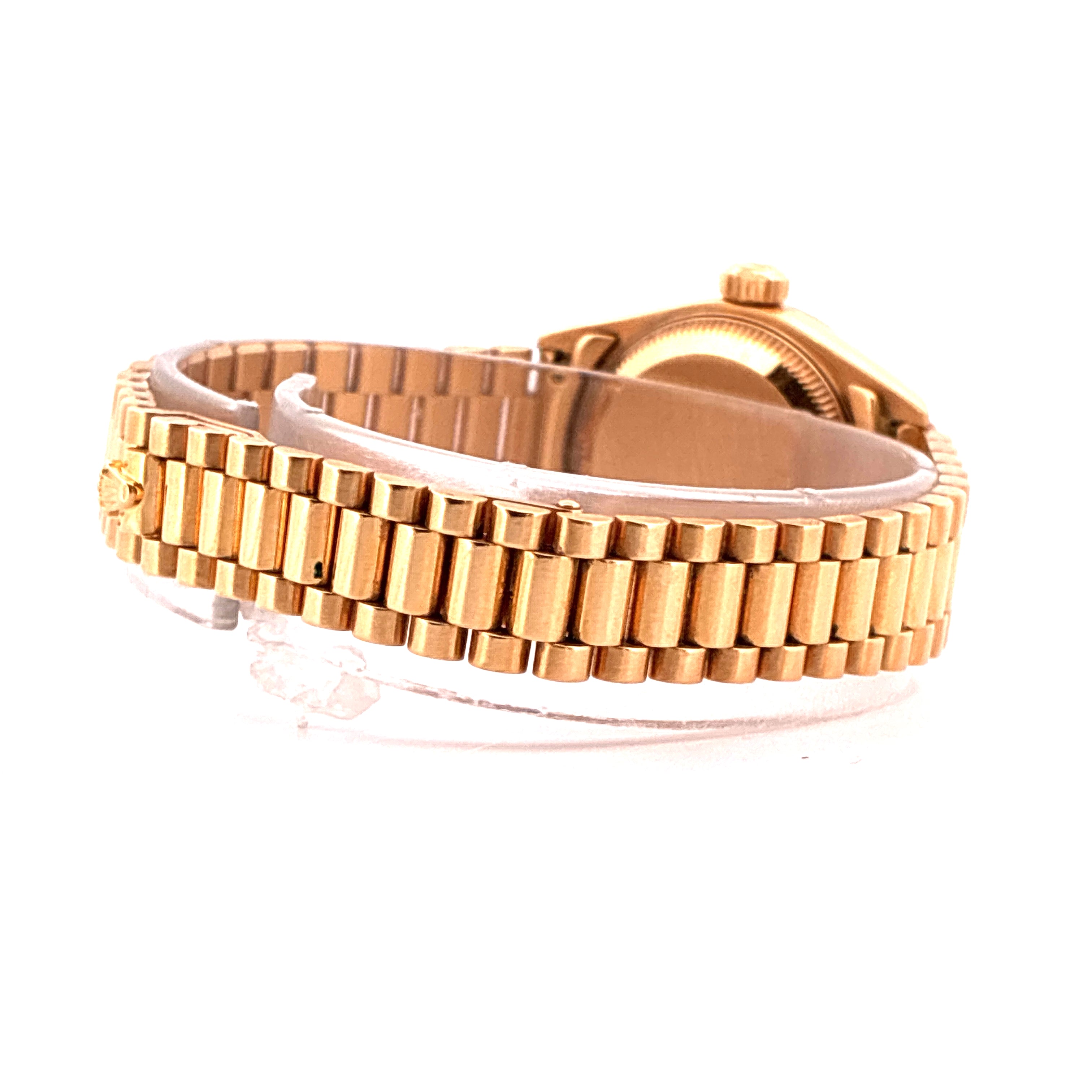 Seitenansicht einer goldenen Rolex Lady-Datejust mit einem polierten Präsidentenarmband auf weissem Hintergrund