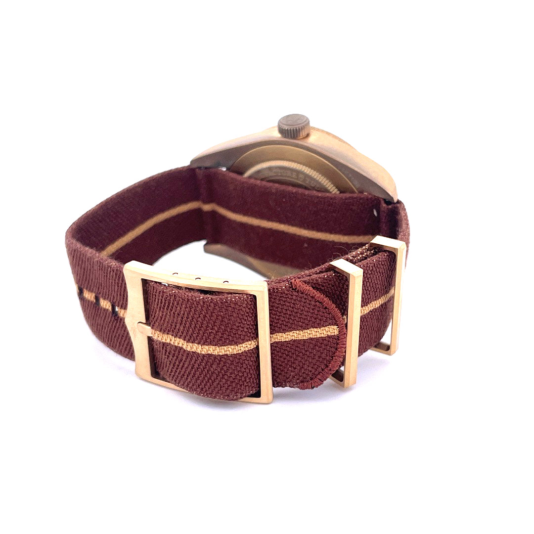 Nahaufnahme des Tudor Black Bay Fifty-eight Boutique Edition mit bronzefarbenem Gehäuse und burgunderrotem Textilband