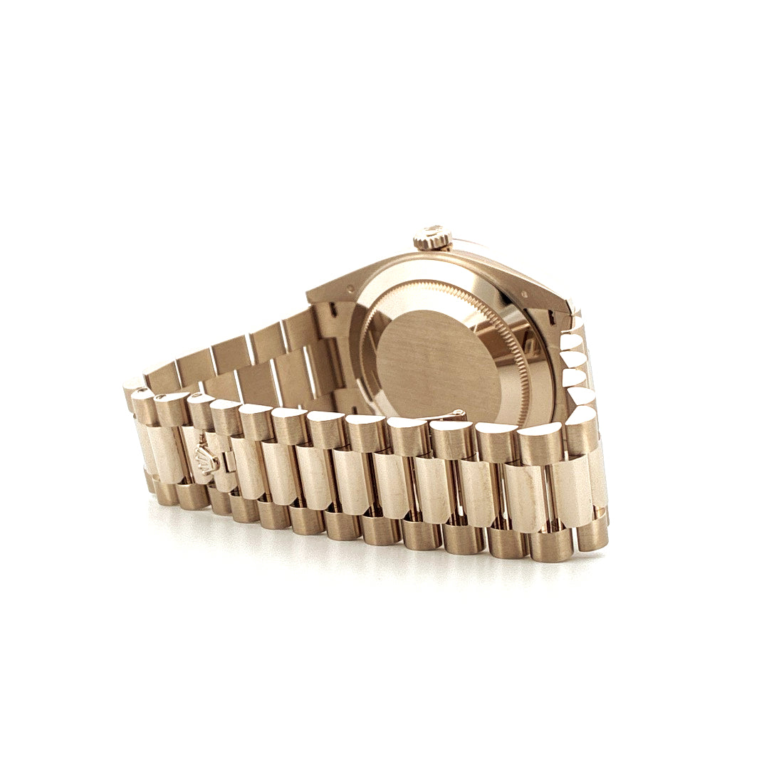 Rückansicht einer Rolex Day-Date 40 aus Roségold mit Oyster-Band auf weißem Hintergrund