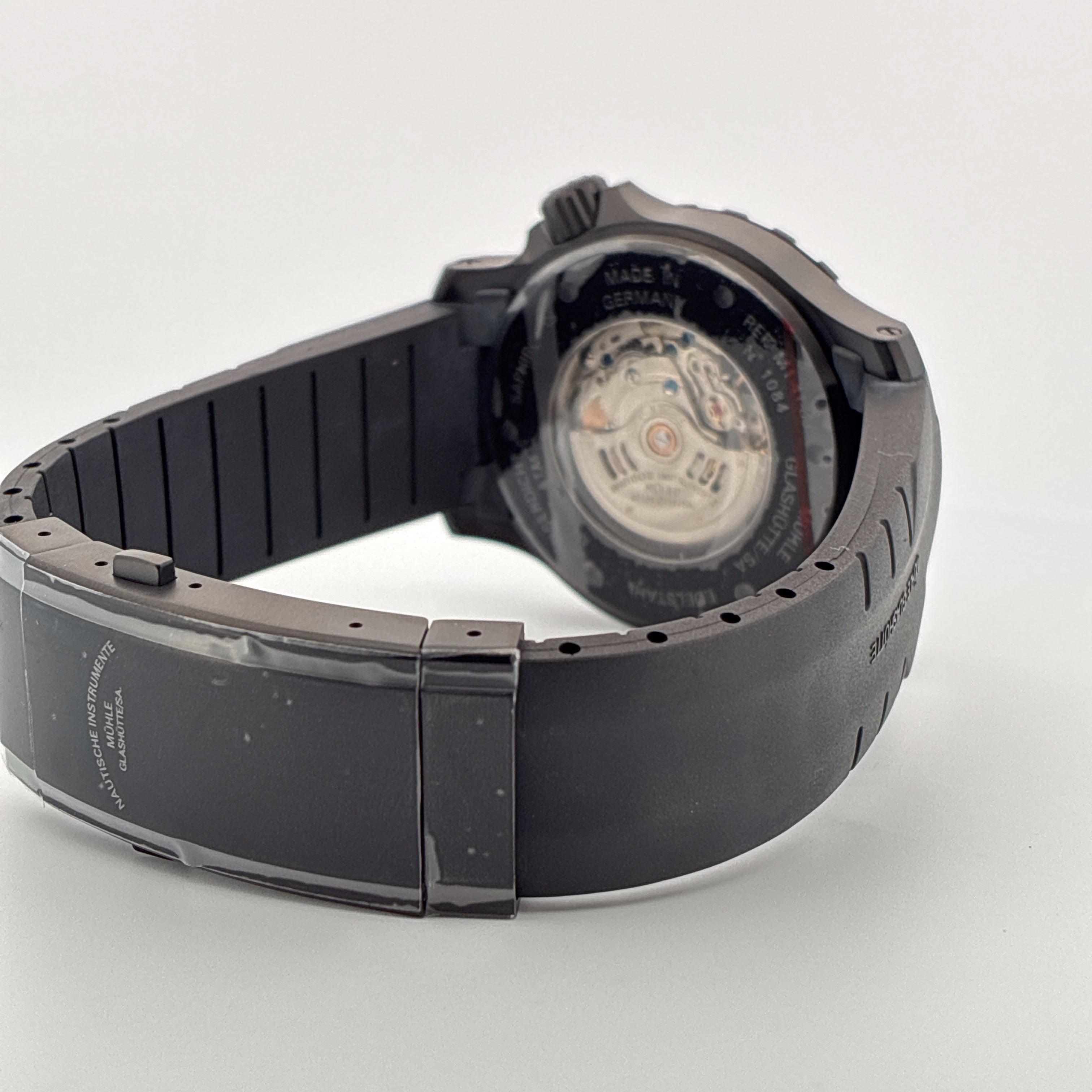 Mühle Glashütte Sea-timer Blackmotion Rückansicht mit Automatikwerk und schwarzem Armband auf hellem Hintergrund