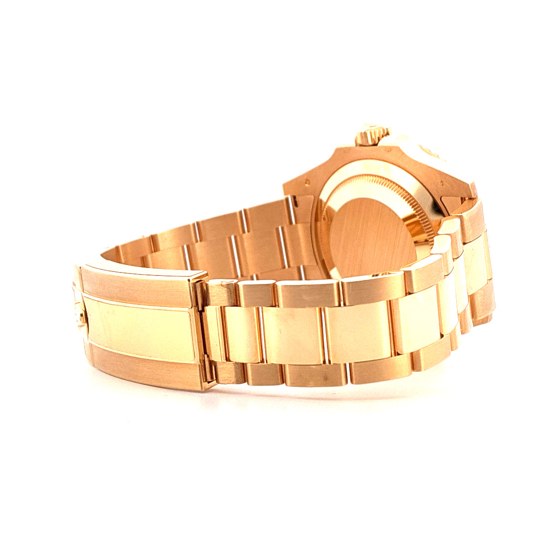 Seitenansicht einer Rolex Submariner Date aus Gelbgold mit poliertem Armband auf weißem Hintergrund