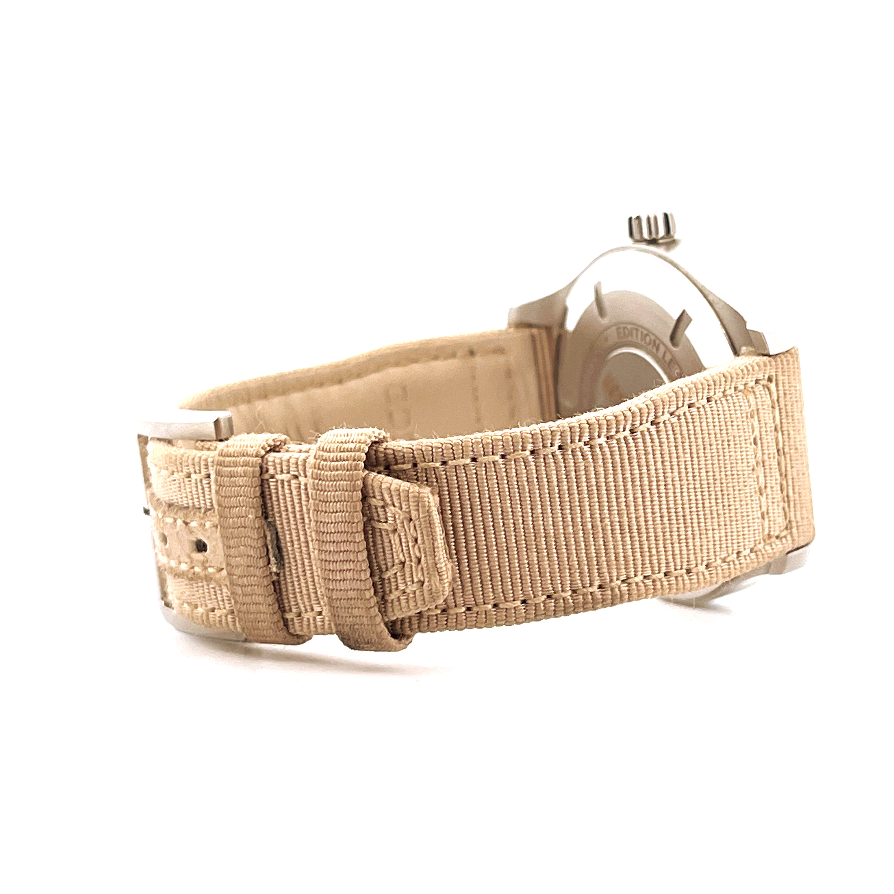 Seitenansicht des IWC Mark XVIII Le Petit Prince mit beigem Textilarmband und Edelstahldetails auf weißem Hintergrund