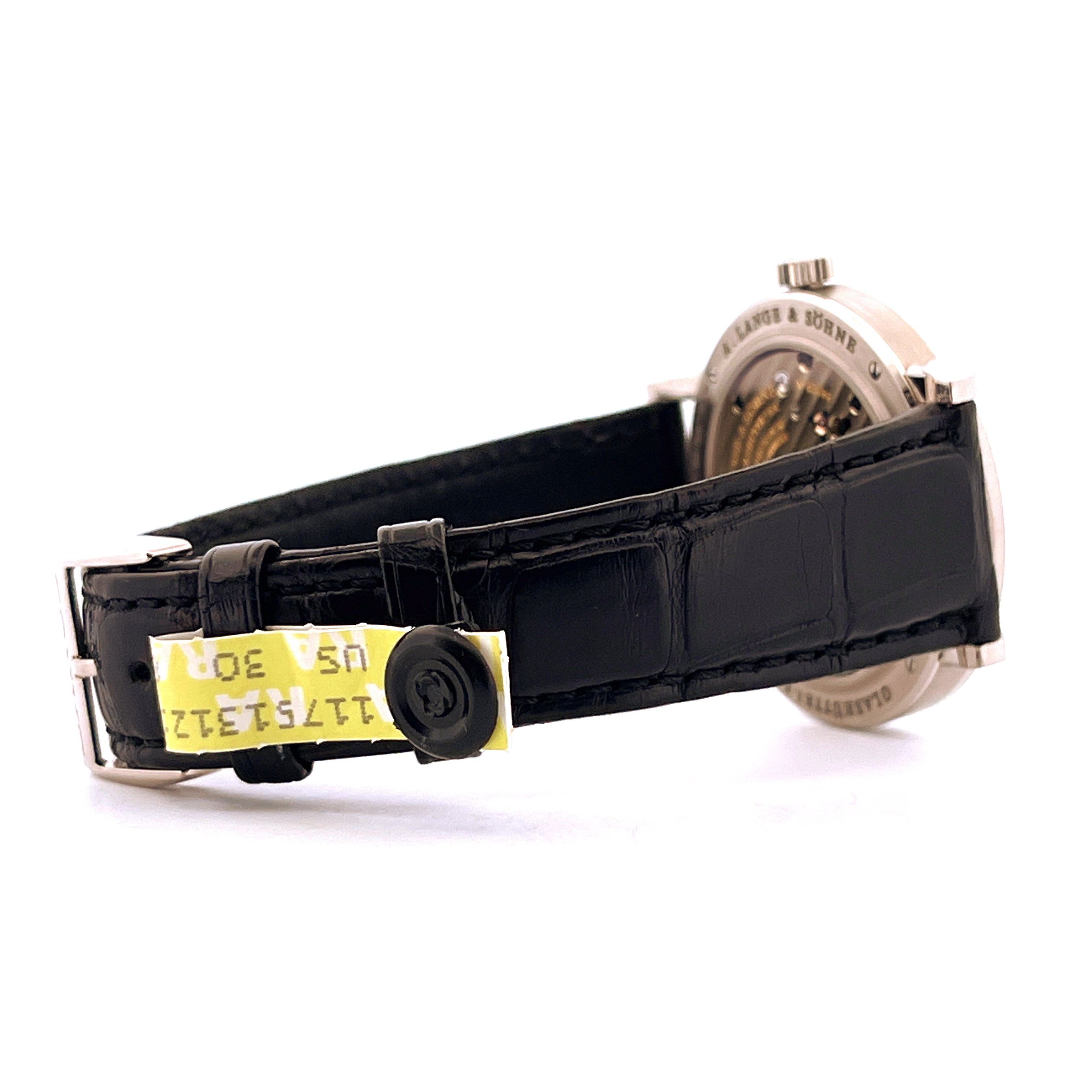 Seitenansicht einer A. Lange & Söhne 1815 Uhr mit schwarzem Lederarmband und gelbem Anhänger