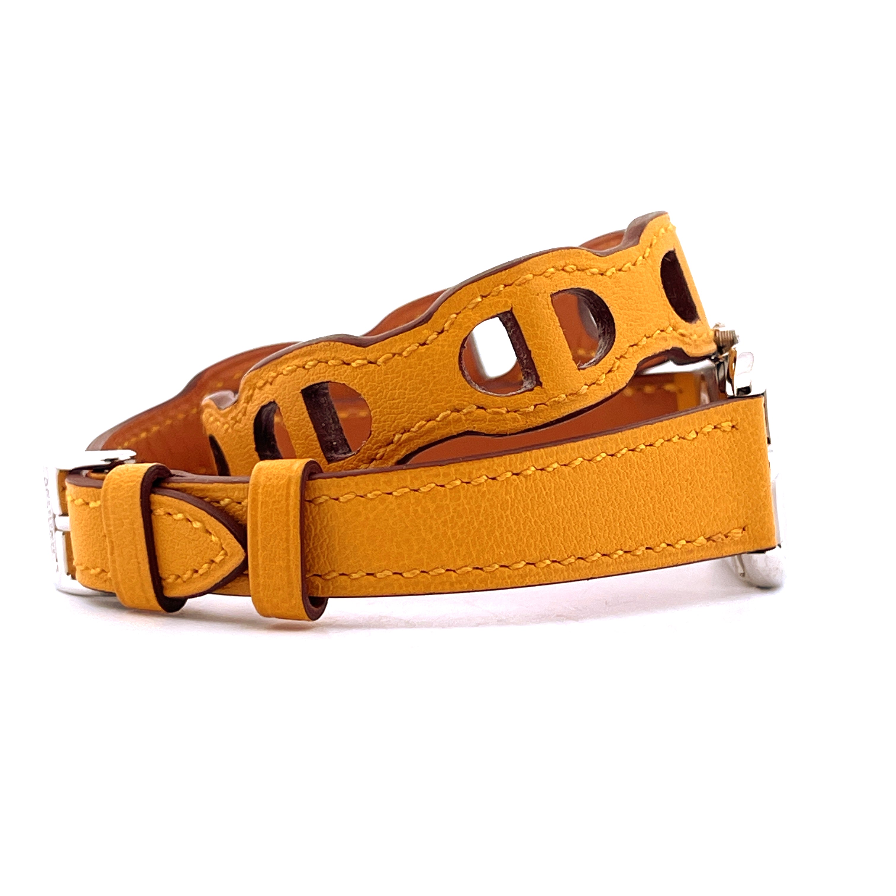 Hermès Cape Cod Armband aus senfgelbem Leder mit eingravierten D-Formen auf weißem Hintergrund