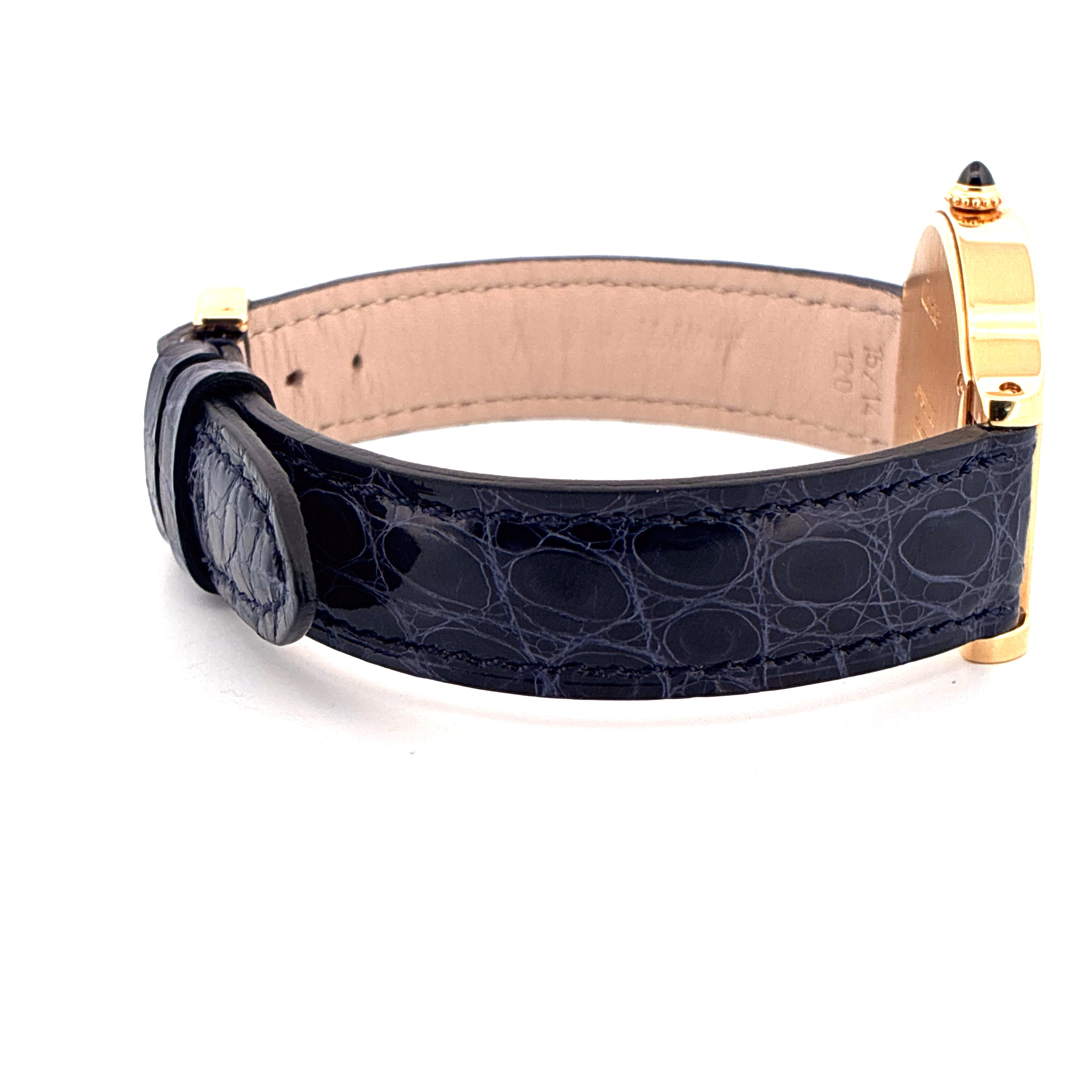 Seitenansicht eines Cartier Cloche De Cartier Gehäuses aus Gelbgold mit dunkelblauem Alligatorlederarmband auf weißem Hint…