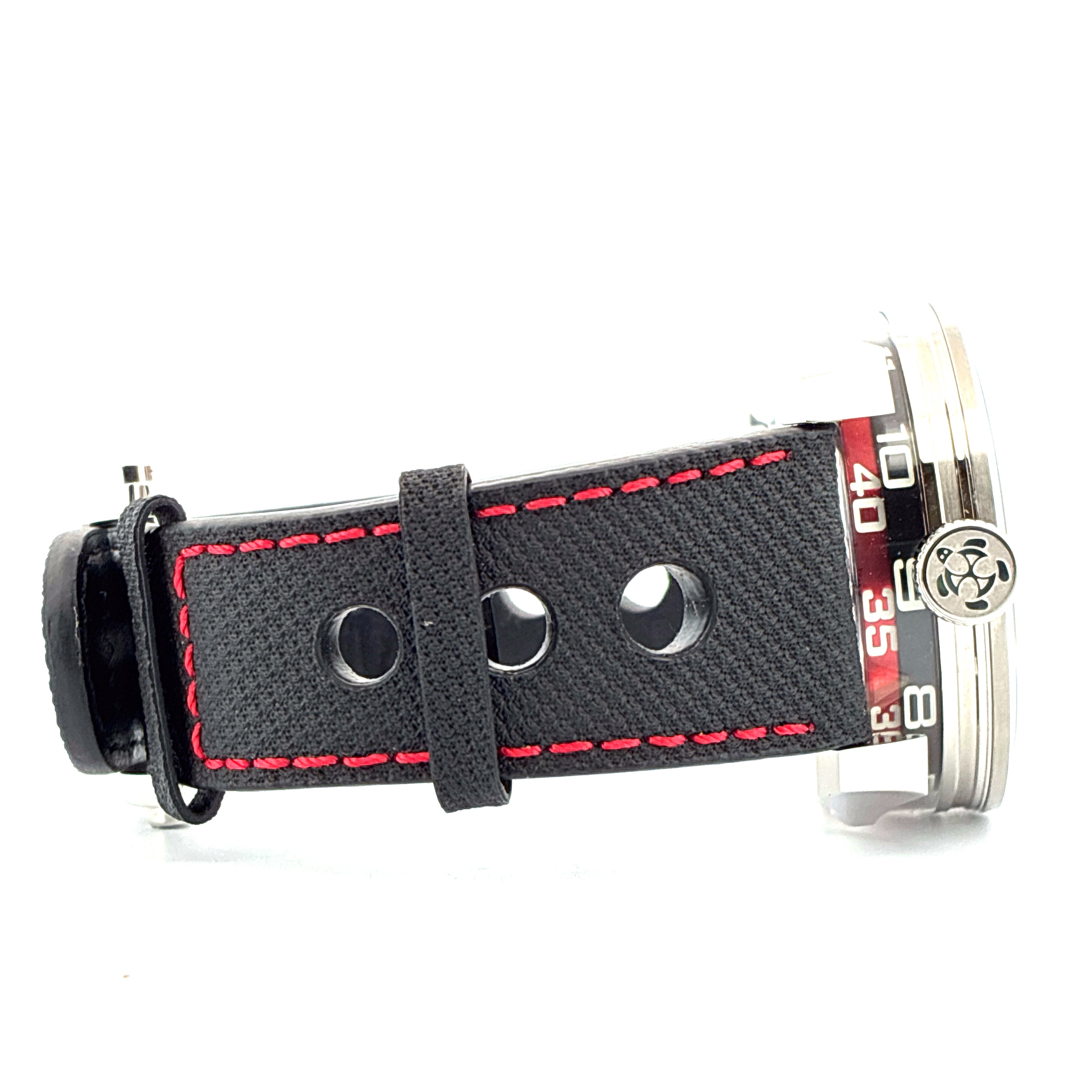 Seitenansicht einer MB&F M.A.D. 1 Edition Uhr mit schwarzem Textilarmband und roten Nähten