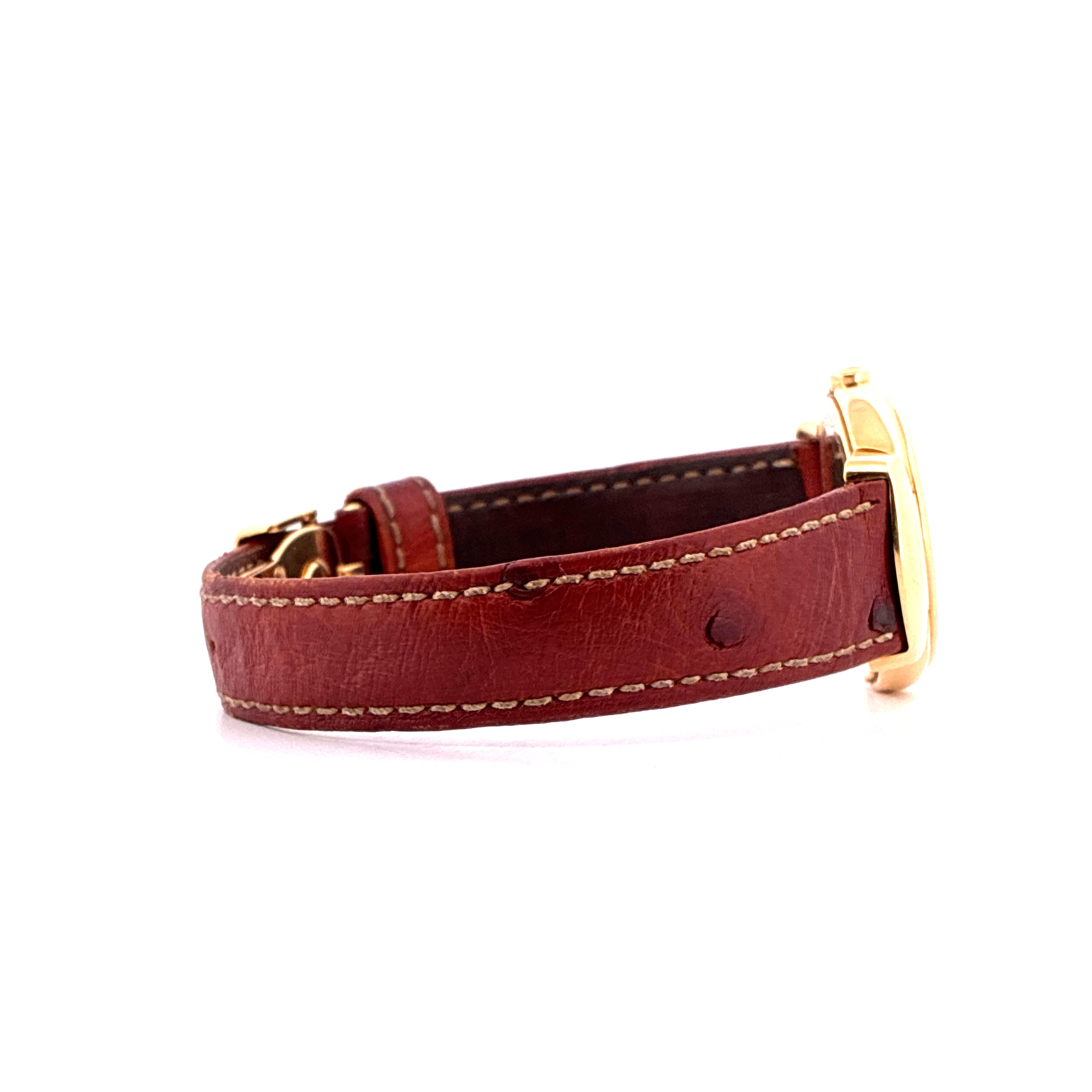 Seitenansicht eines roten Lederarmbands einer Rolex Cellini Uhr mit goldenen Anstosskappen auf weissem Hintergrund