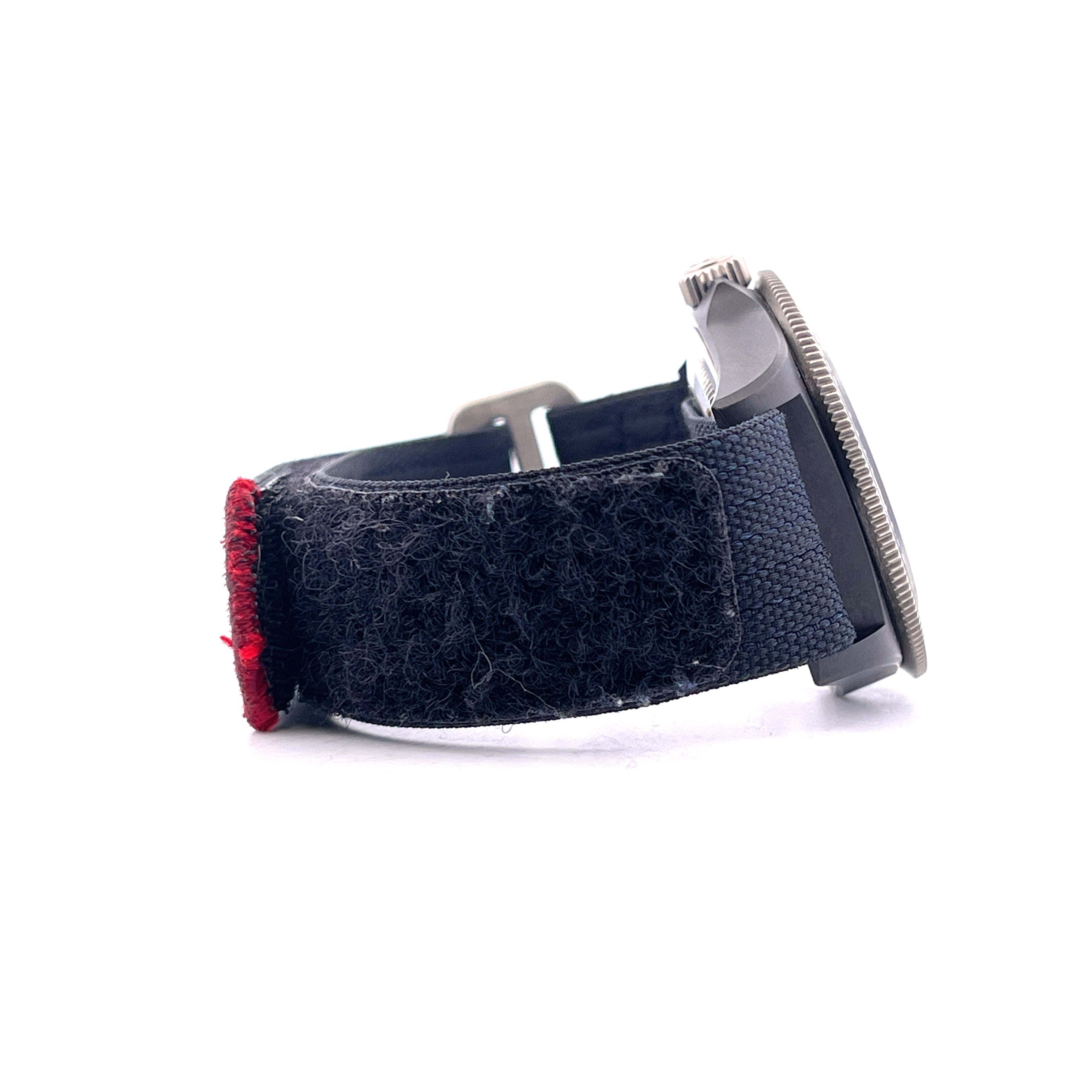 Seitenansicht einer Tudor Alinghi Red Bull Pelagos FXD Uhr mit schwarzem Klettband und roter Naht