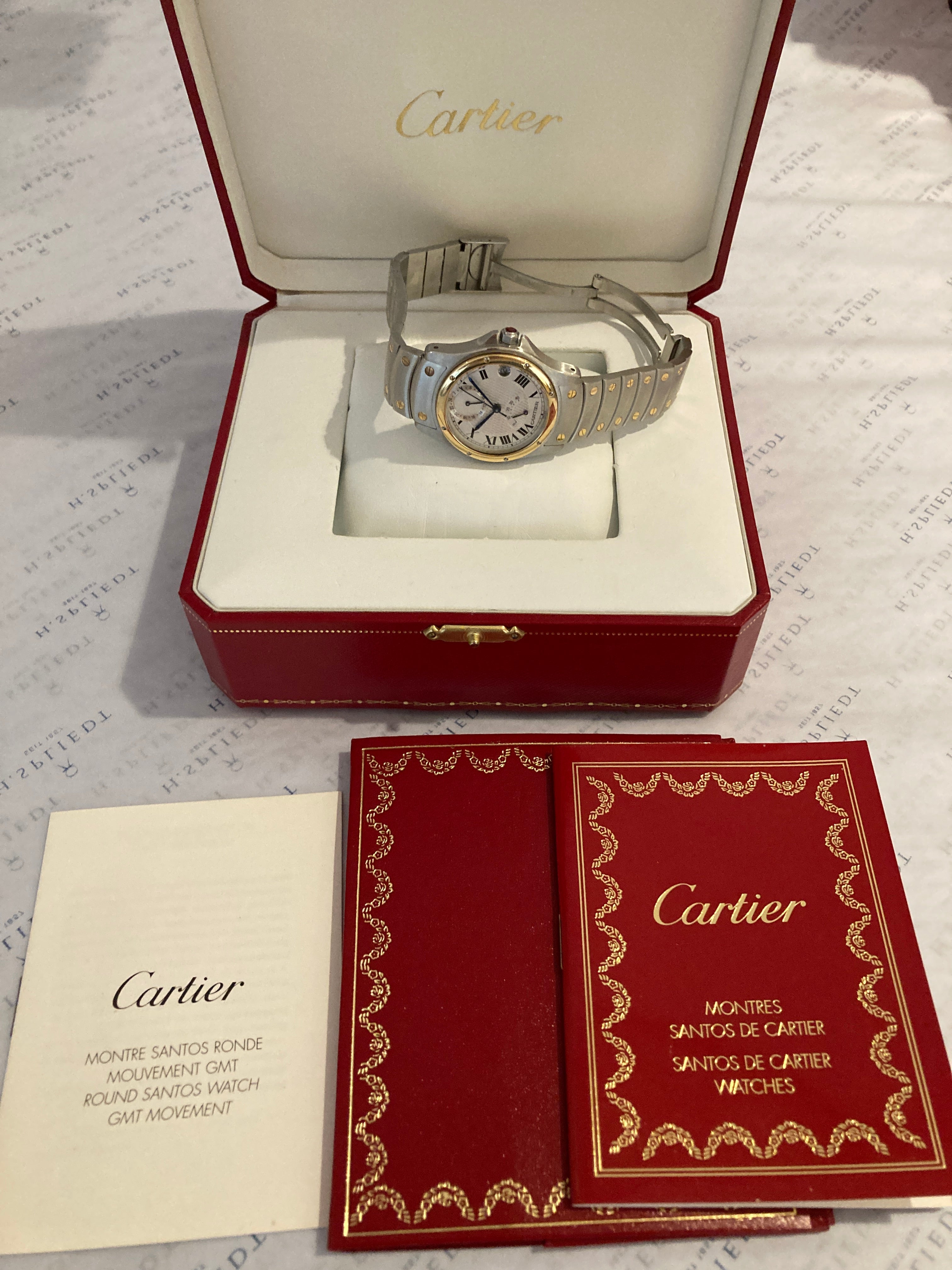Cartier Santos Ronde 150th Automatic 1997 aus Stahl und Gold auf weißem Untergrund mit Zubehör