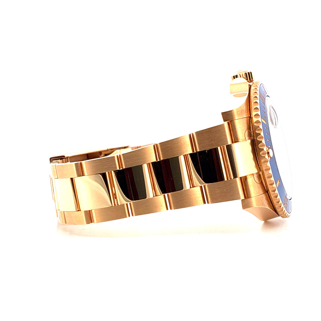 Rolex Submariner Date Full Gold von der Seite auf weißem Hintergrund mit blauer Lünette