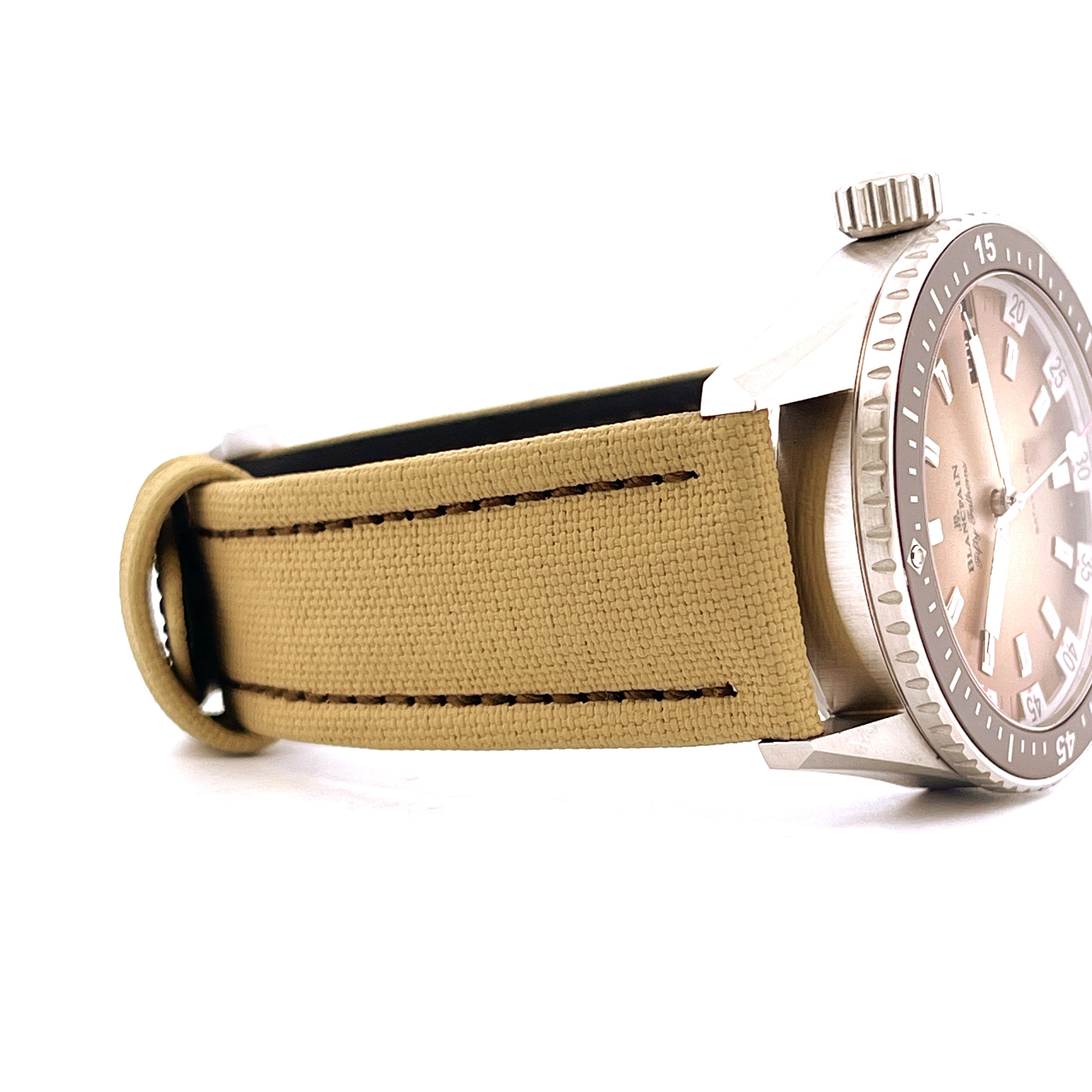 Seitenansicht einer Blancpain Fifty Fathoms Uhr mit braunem Textilarmband, Stahlgehäuse und hellbraunem Zifferblatt