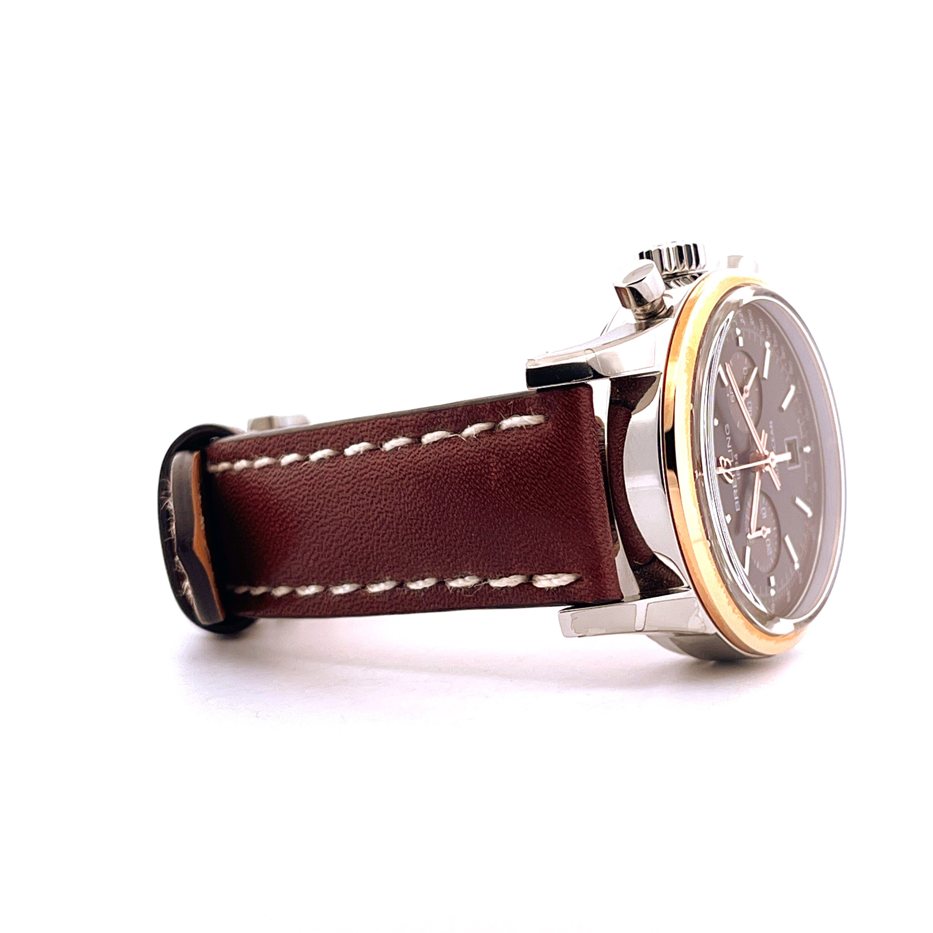 Seitenansicht eines Breitling Transocean Chronograph 38 mit Edelstahl-Goldgehäuse und braunem Lederarmband