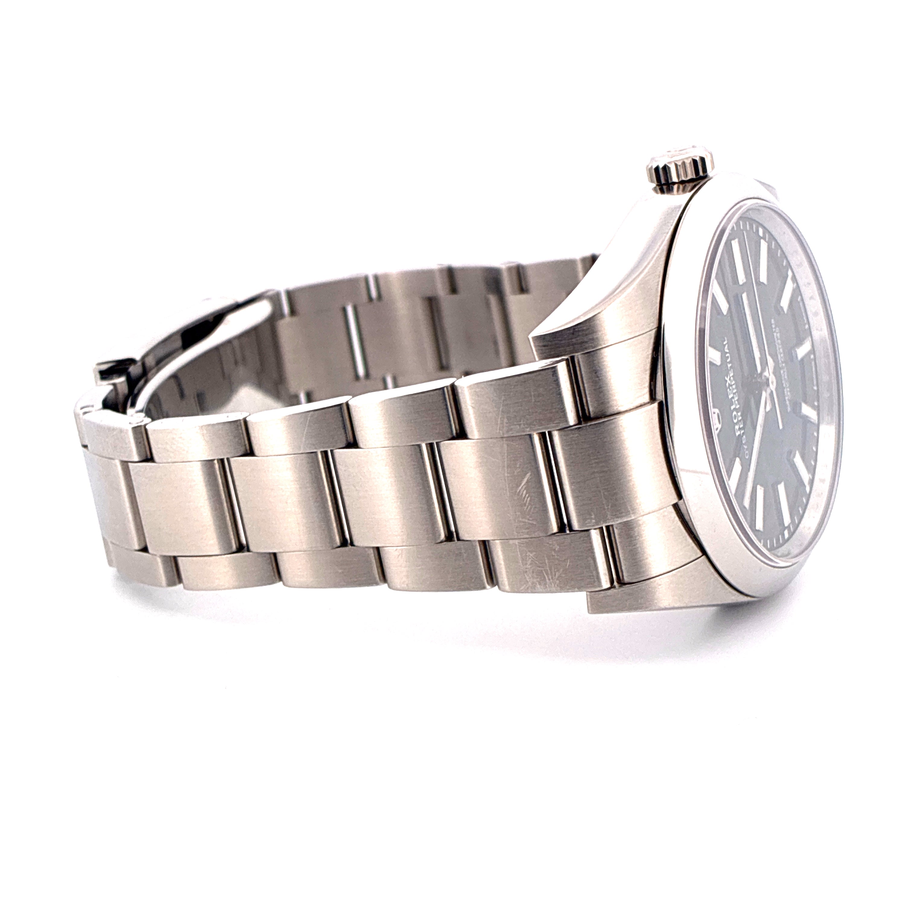 Rolex Oyster Perpetual 39 mit schwarzem Zifferblatt und Stahlarmband, Seitenansicht auf weissem Hintergrund