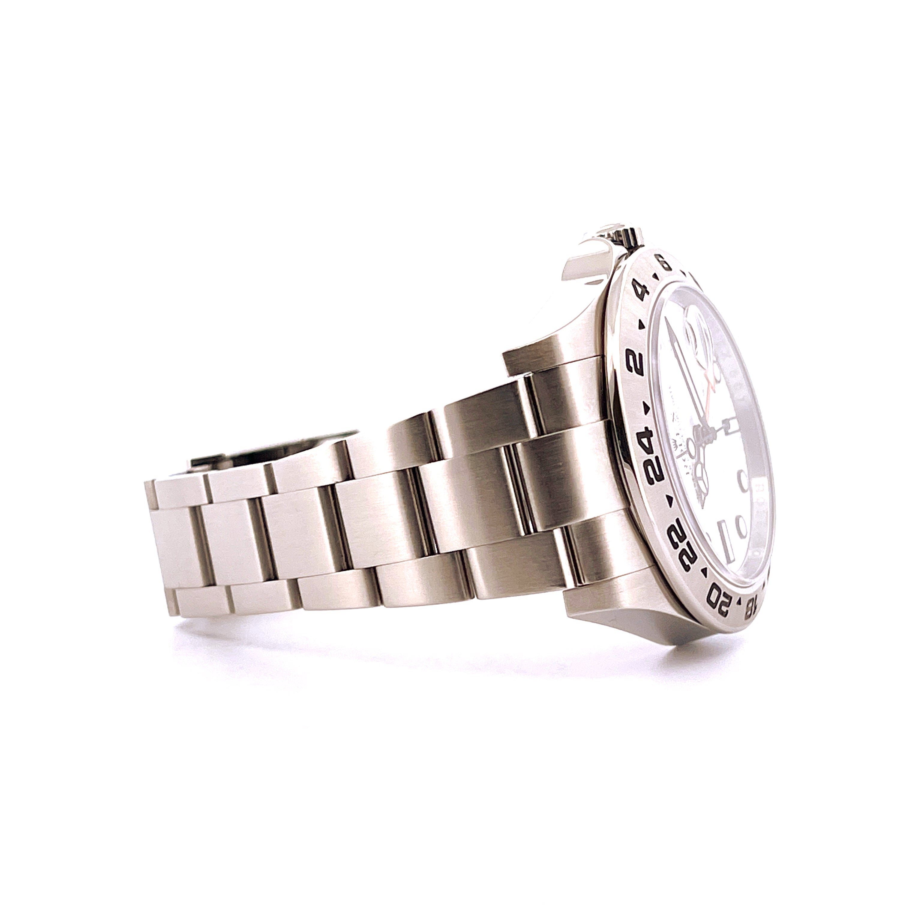 Rolex Explorer II Polar Dial aus Stahl, Seitenansicht auf weißem Hintergrund mit silbernem Armband und Lünettenanzeige