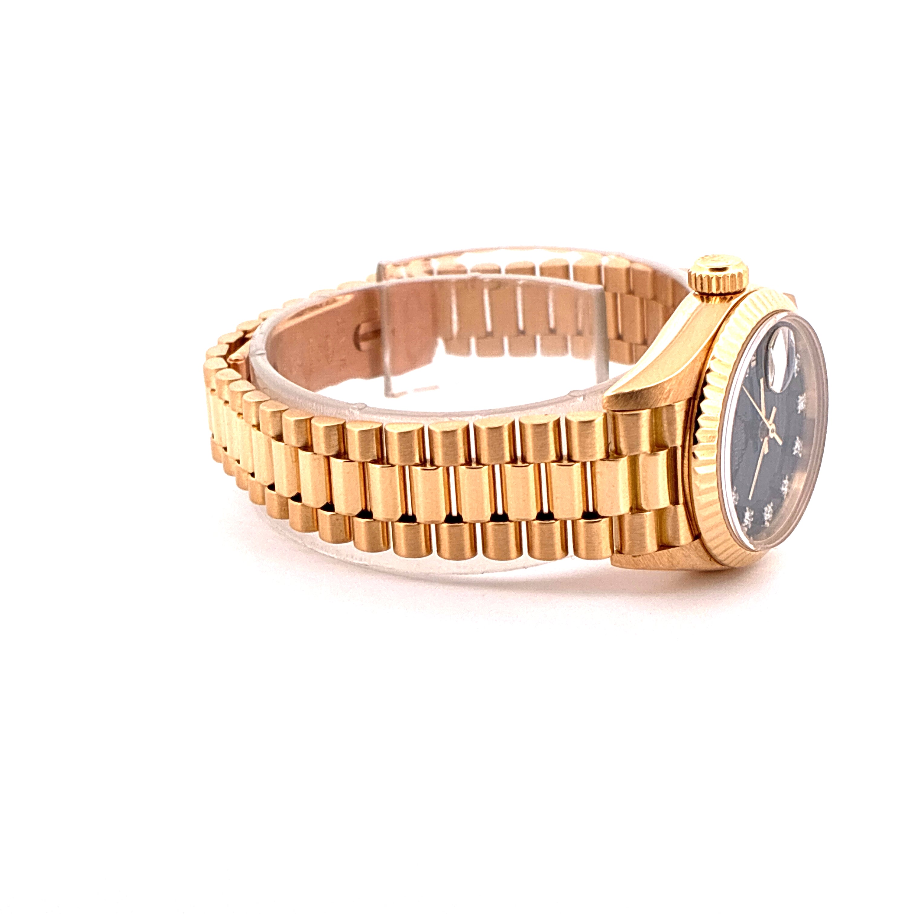 Eine goldene Rolex Lady-Datejust mit schwarzem Zifferblatt und 10 Diamanten auf weissem Hintergrund