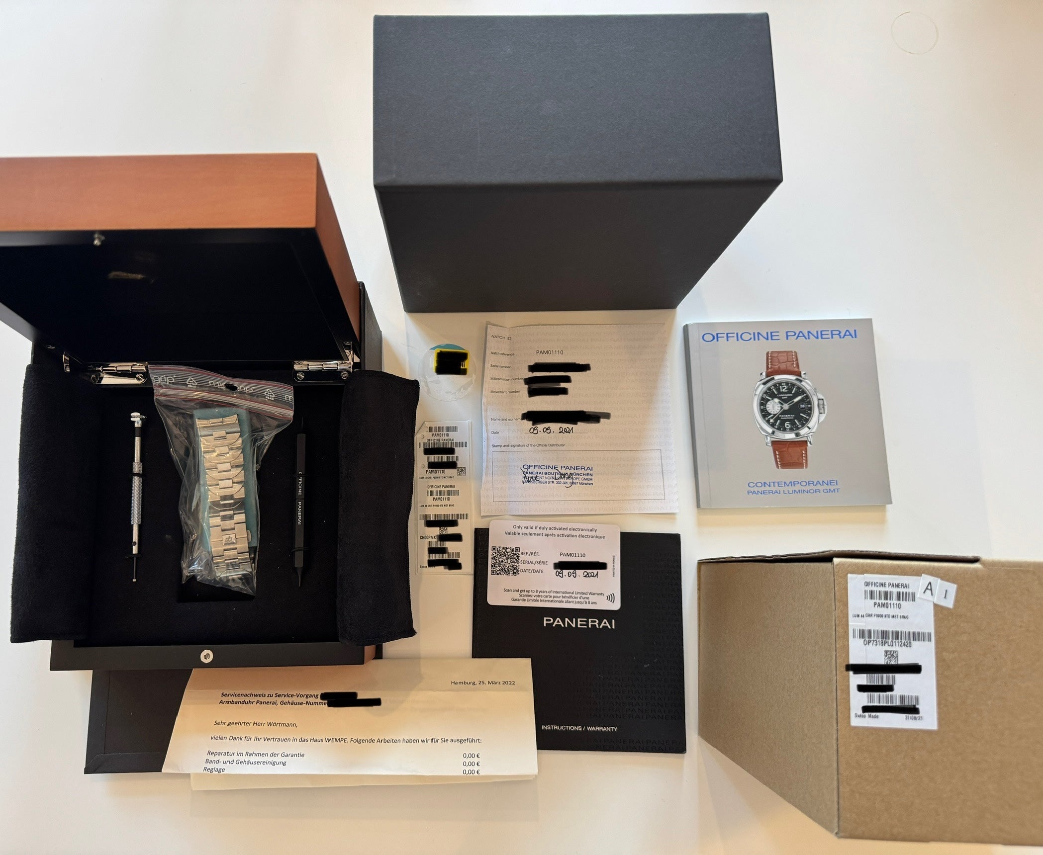 Panerai Luminor Chrono Pam01110 im geöffneten Holz- und Pappkarton mit Papieren und Werkzeug