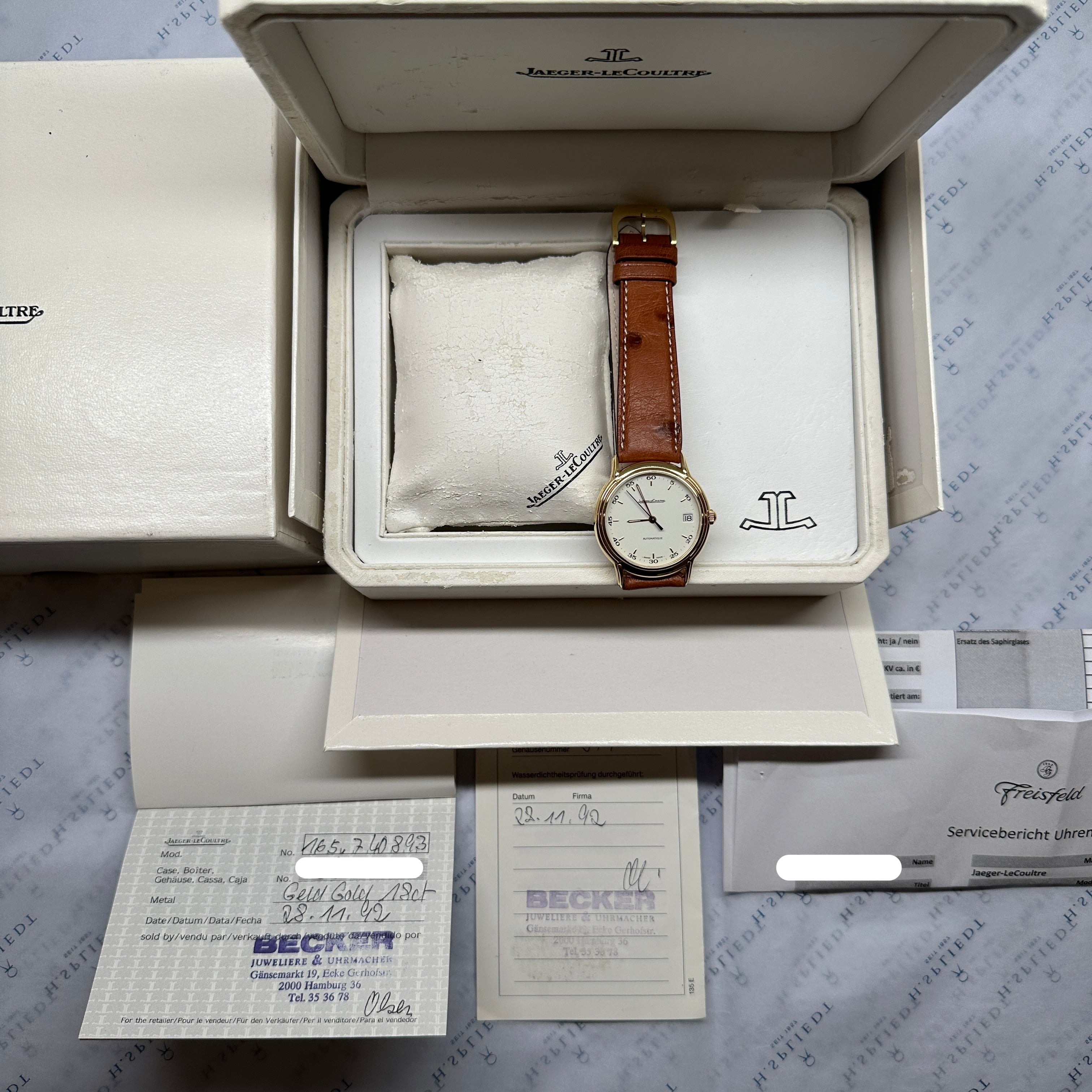 Jaeger LeCoultre Odysseus Automatik 18k Gold Uhr im Full Set auf grauem Hintergrund