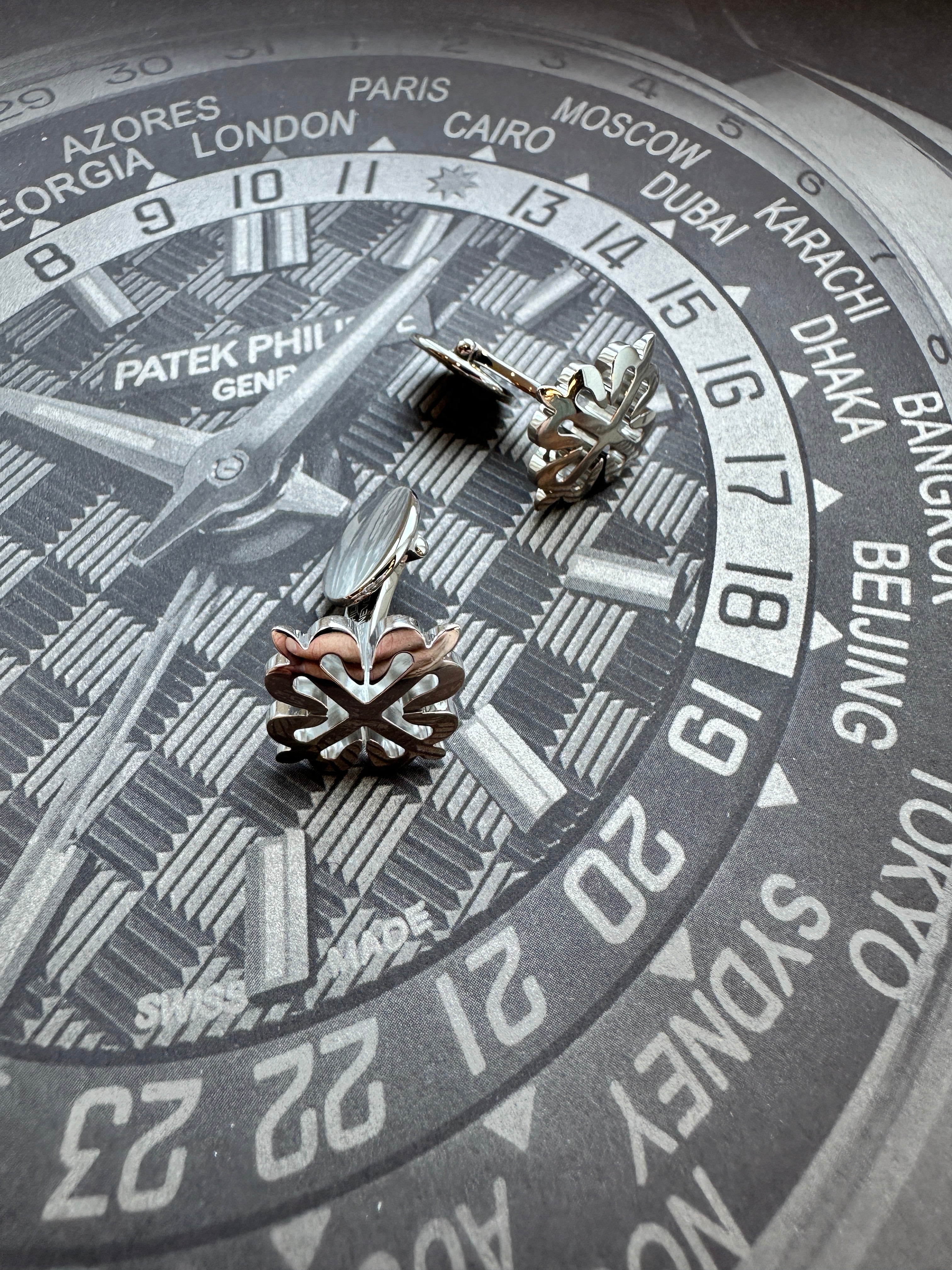 Patek Philippe Calatrava Kreuz Manschettenknöpfe aus 18 Karat Weißgold liegen auf dem Zifferblatt einer Uhr