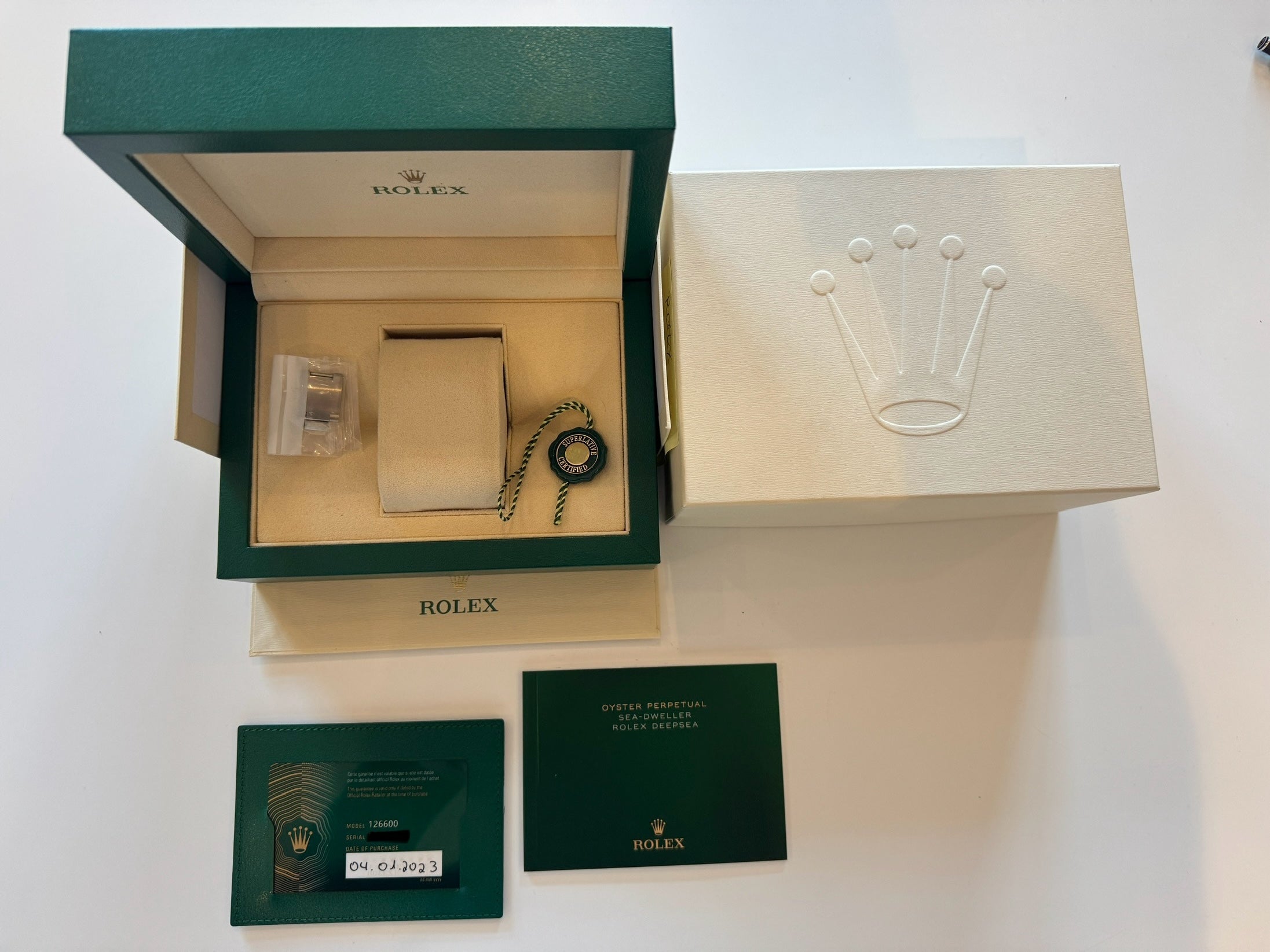 Rolex Sea-Dweller Ref. 126600 im geöffneten grünen Rolex-Karton mit weißer Umverpackung und Papieren