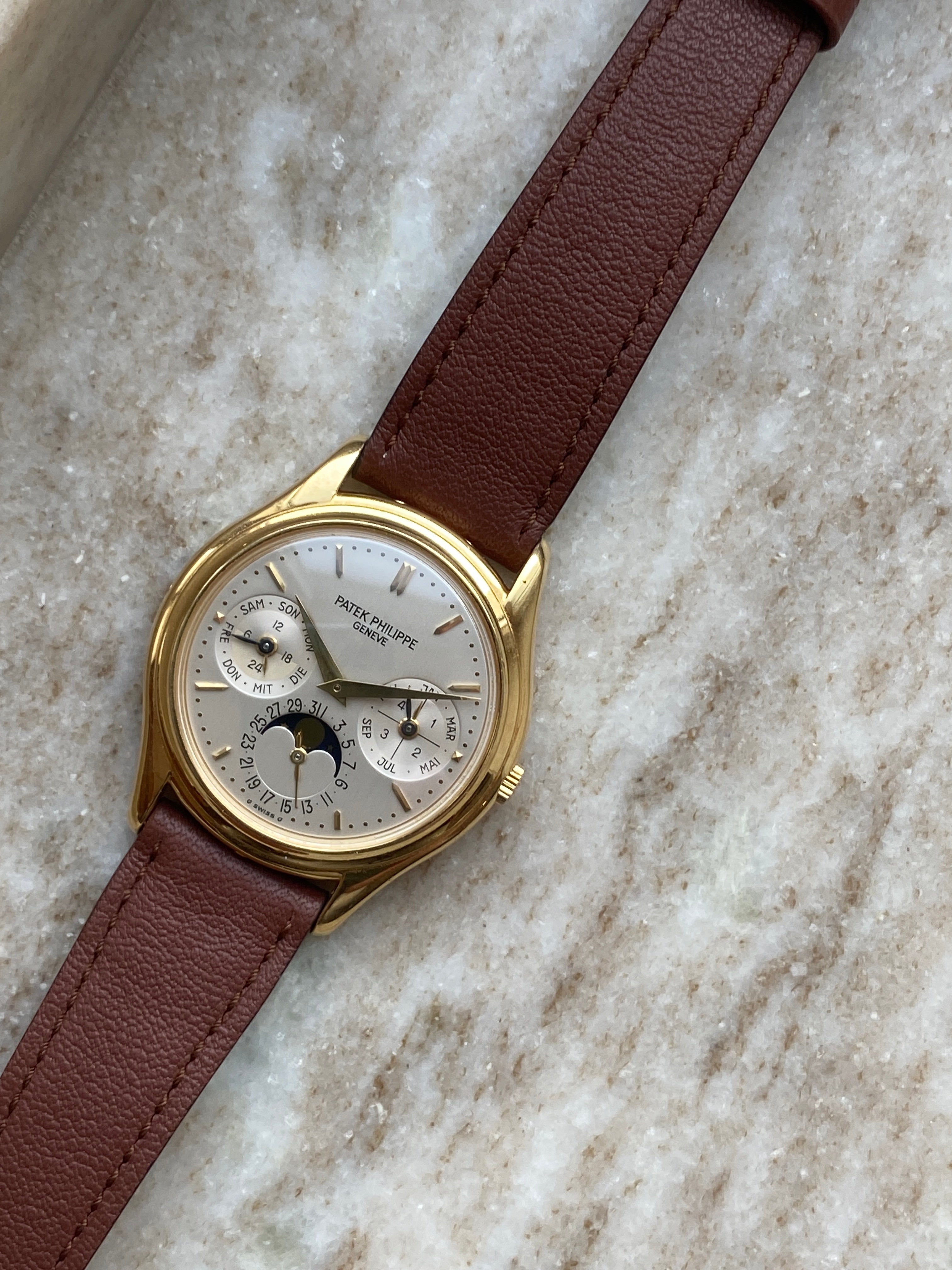 Patek Philippe Perpetual Calendar 3940J-017 in Gelbgold mit braunem Lederarmband auf Marmorhintergrund