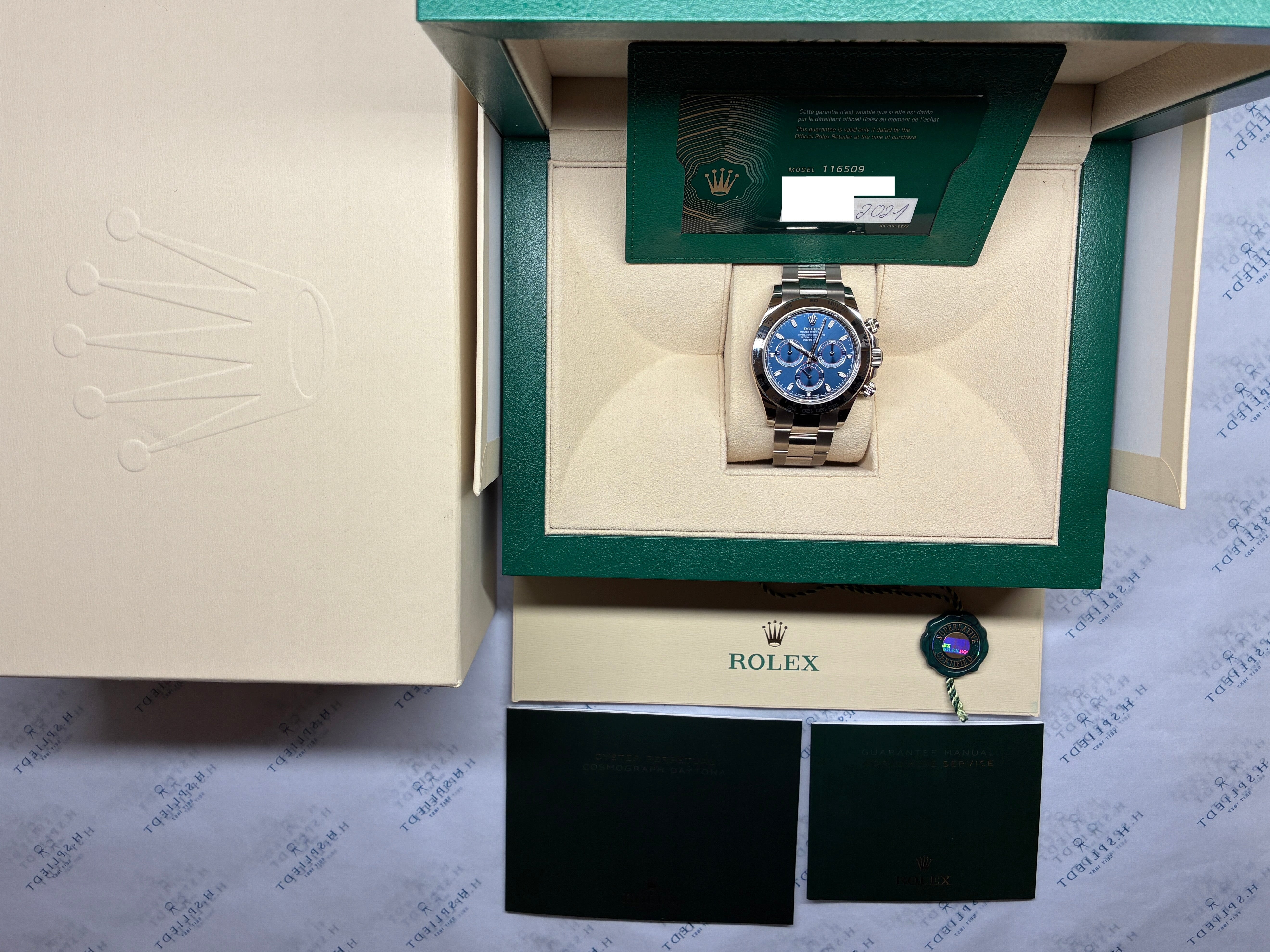 Rolex Daytona Whitegold mit blauem Zifferblatt im geöffneten Karton, detaillierte Ansicht