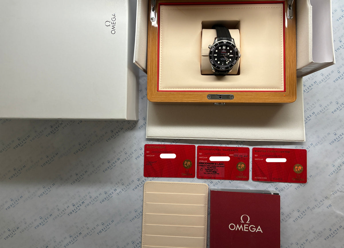 Omega Seamaster Diver 300 M Black / Full Set / very good Condition / Germany / 2021, Gesamtansicht mit Zifferblatt, Box und Unterlagen vor neutralem Hintergrund